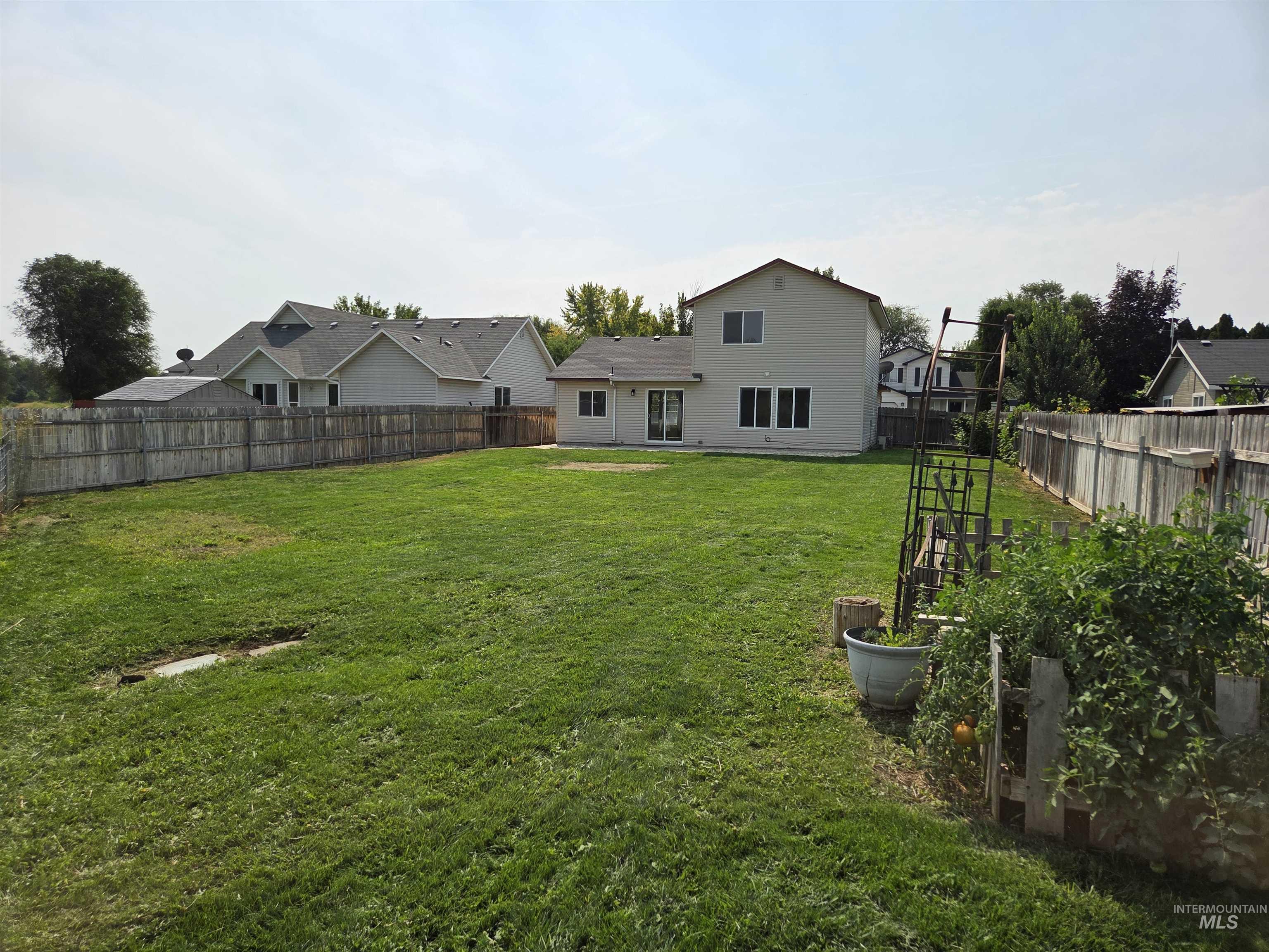 Fenced backyard featuring a patio area and a residential view