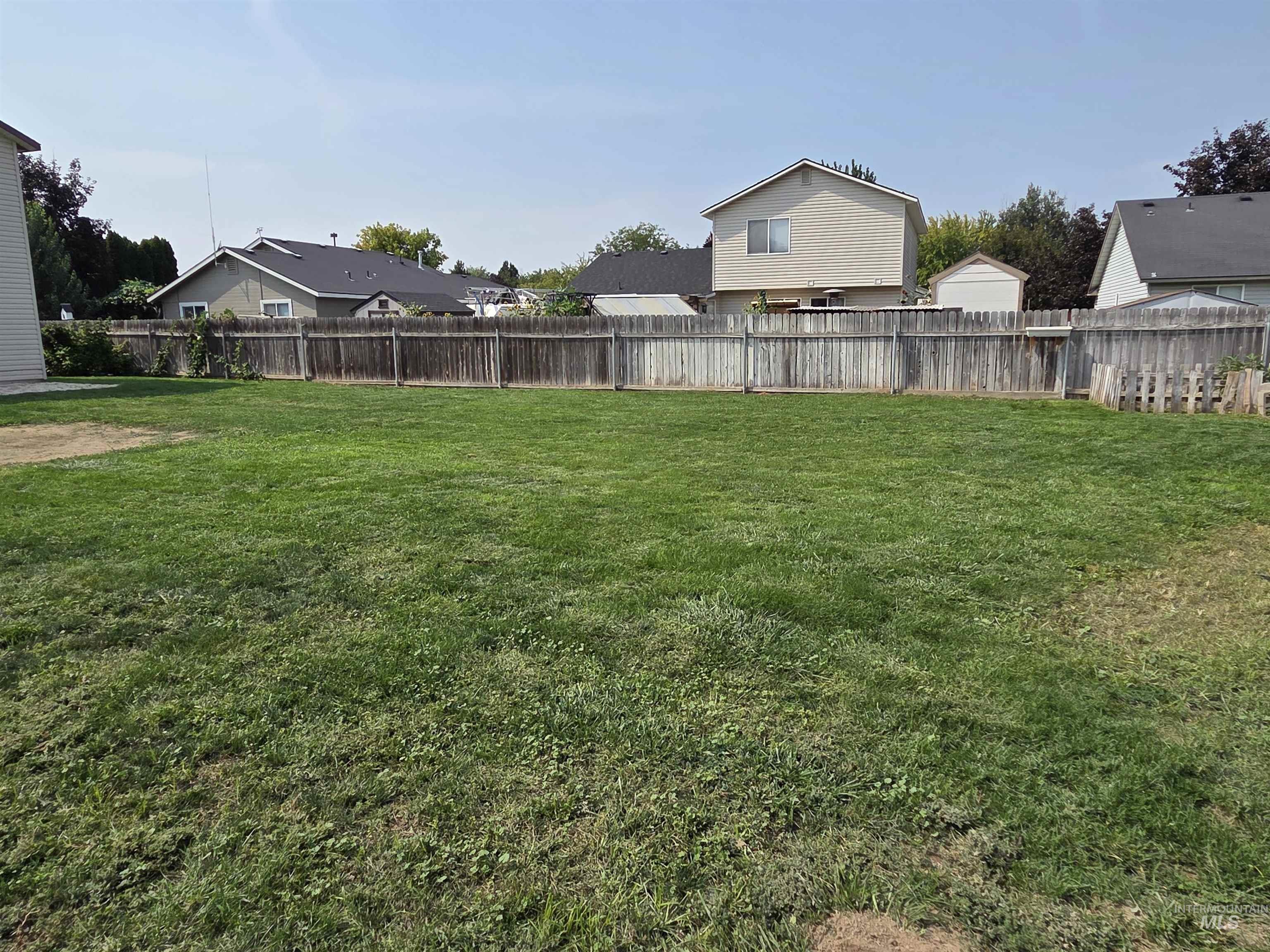 Fenced backyard featuring a residential view