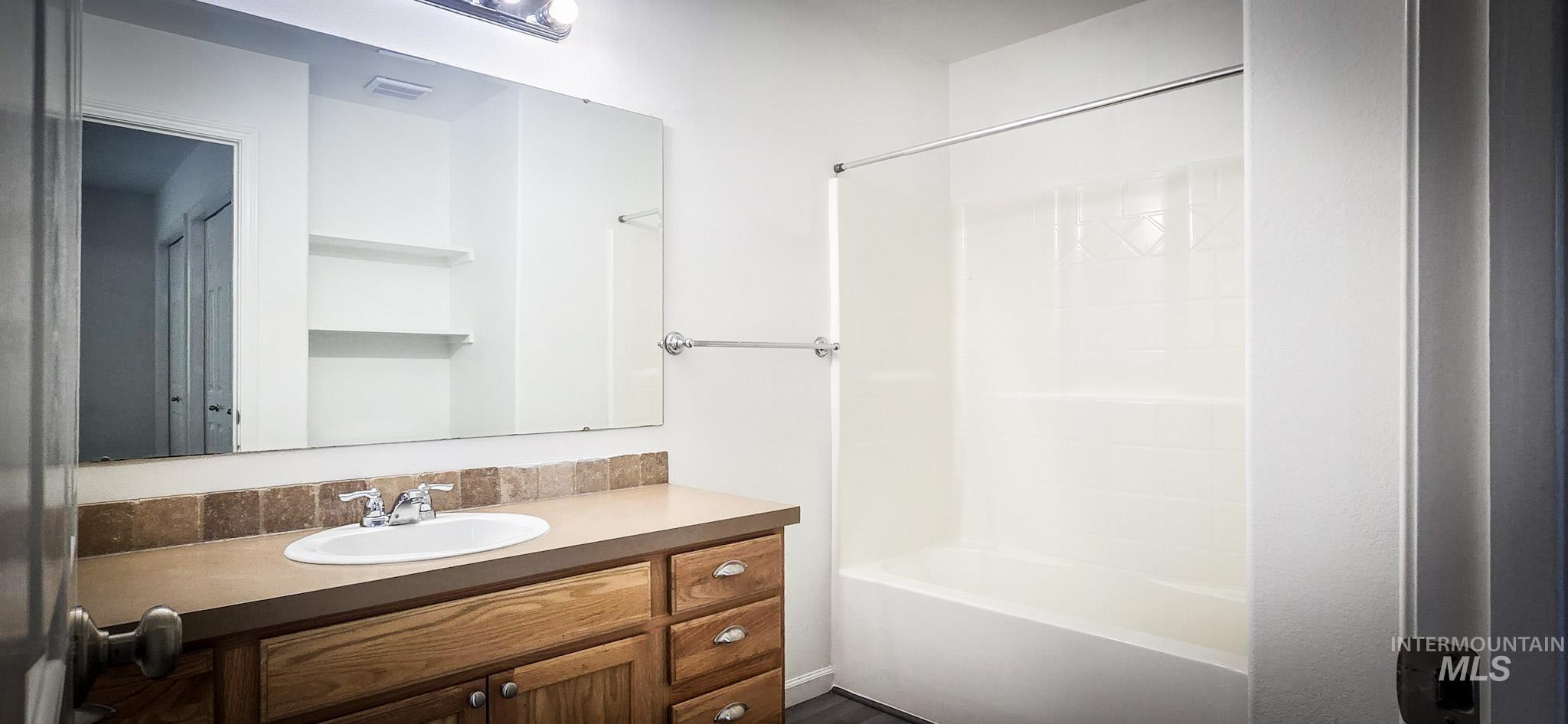 Full bath with vanity and shower / washtub combination