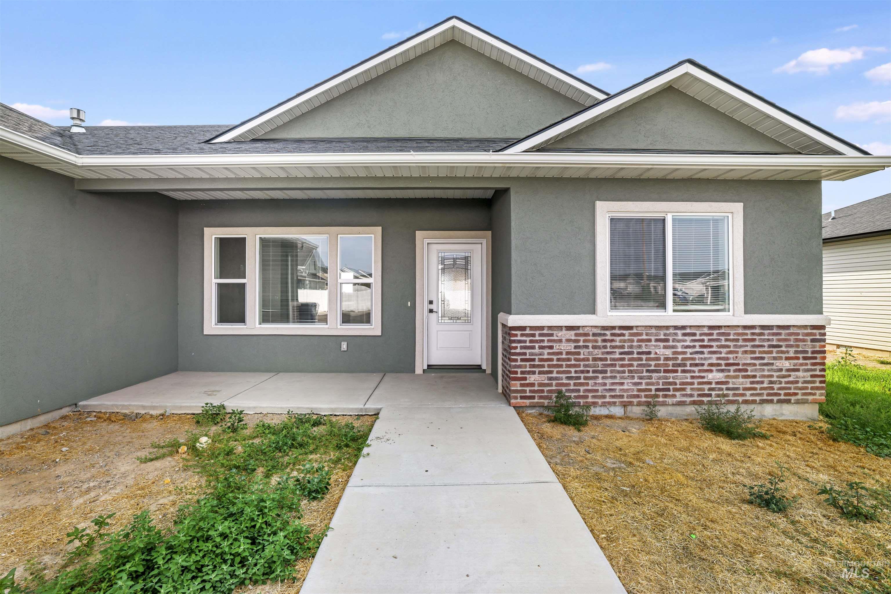 Doorway to property with brick siding, stucco siding, and a porch