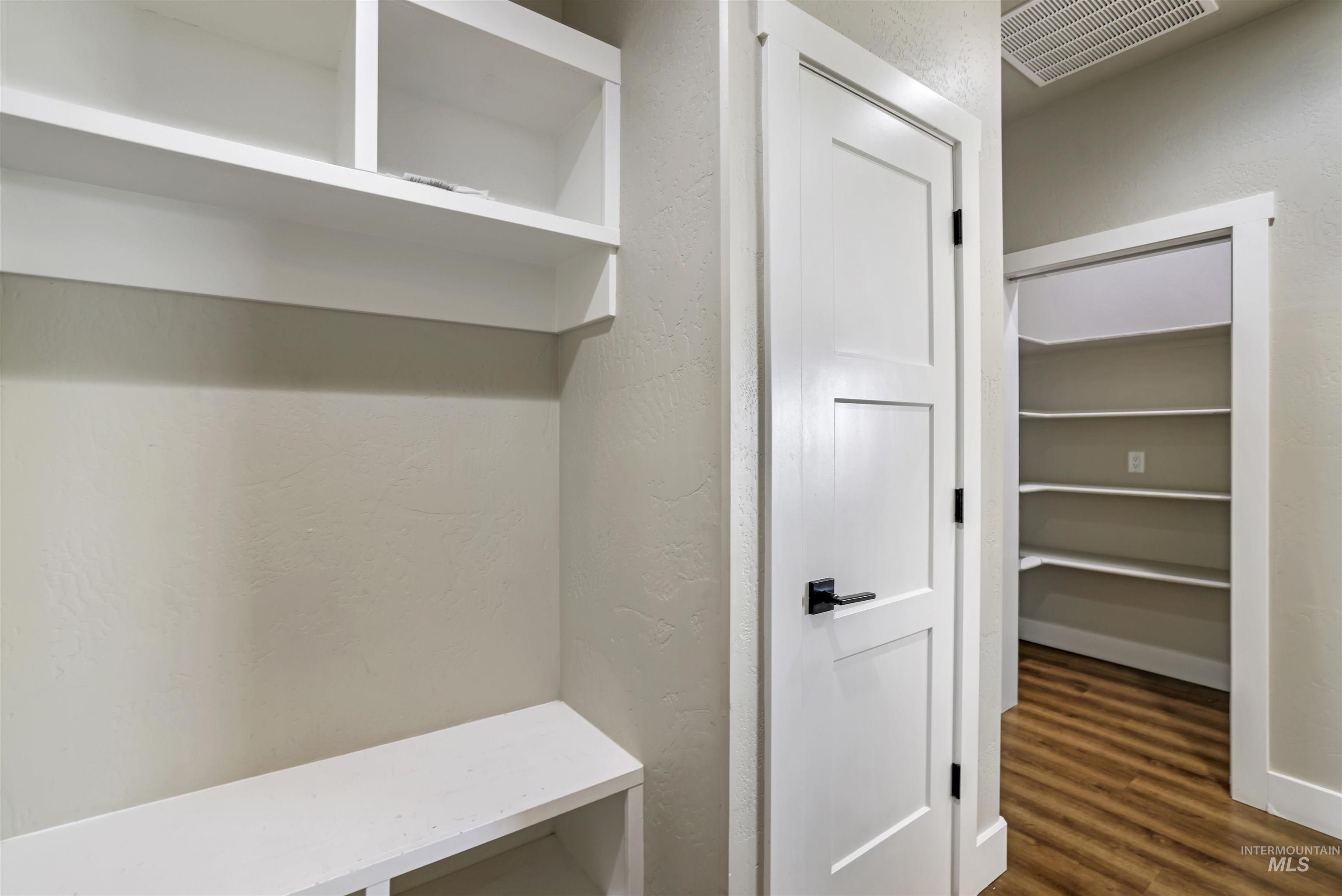 Mudroom featuring a textured wall and dark wood finished floors
