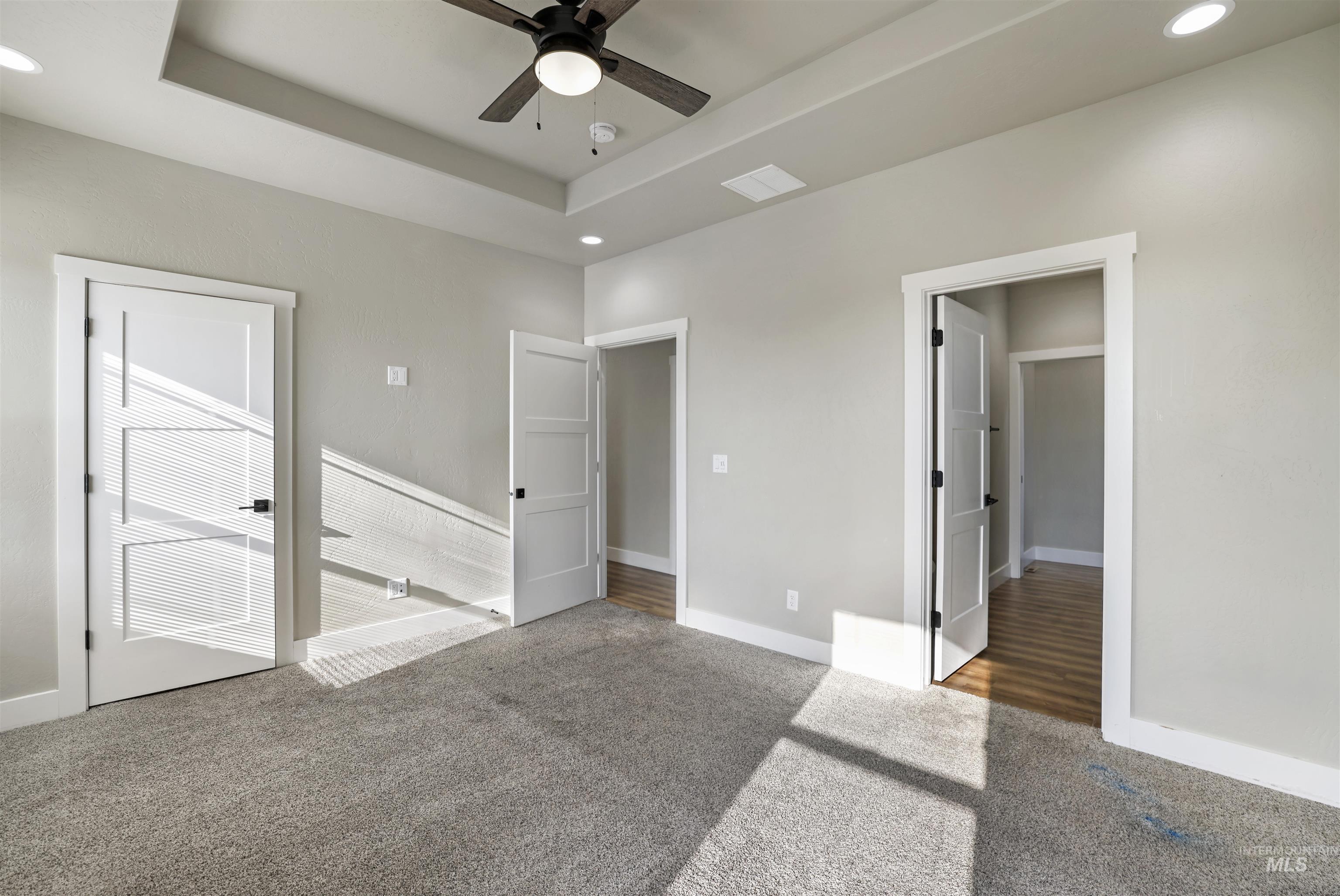 Unfurnished bedroom with recessed lighting, carpet floors, a tray ceiling, and ceiling fan