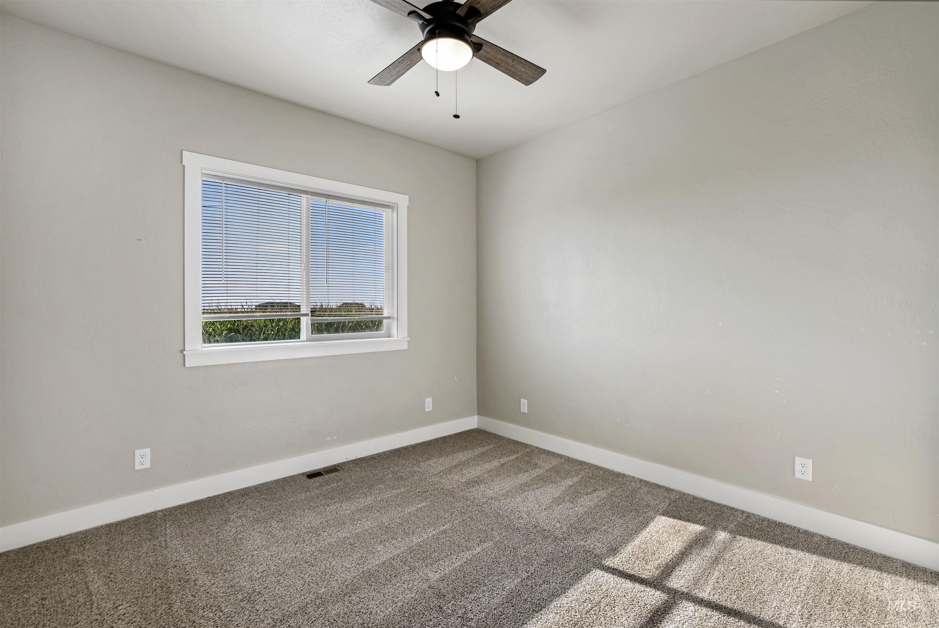 Spare room featuring carpet flooring and ceiling fan
