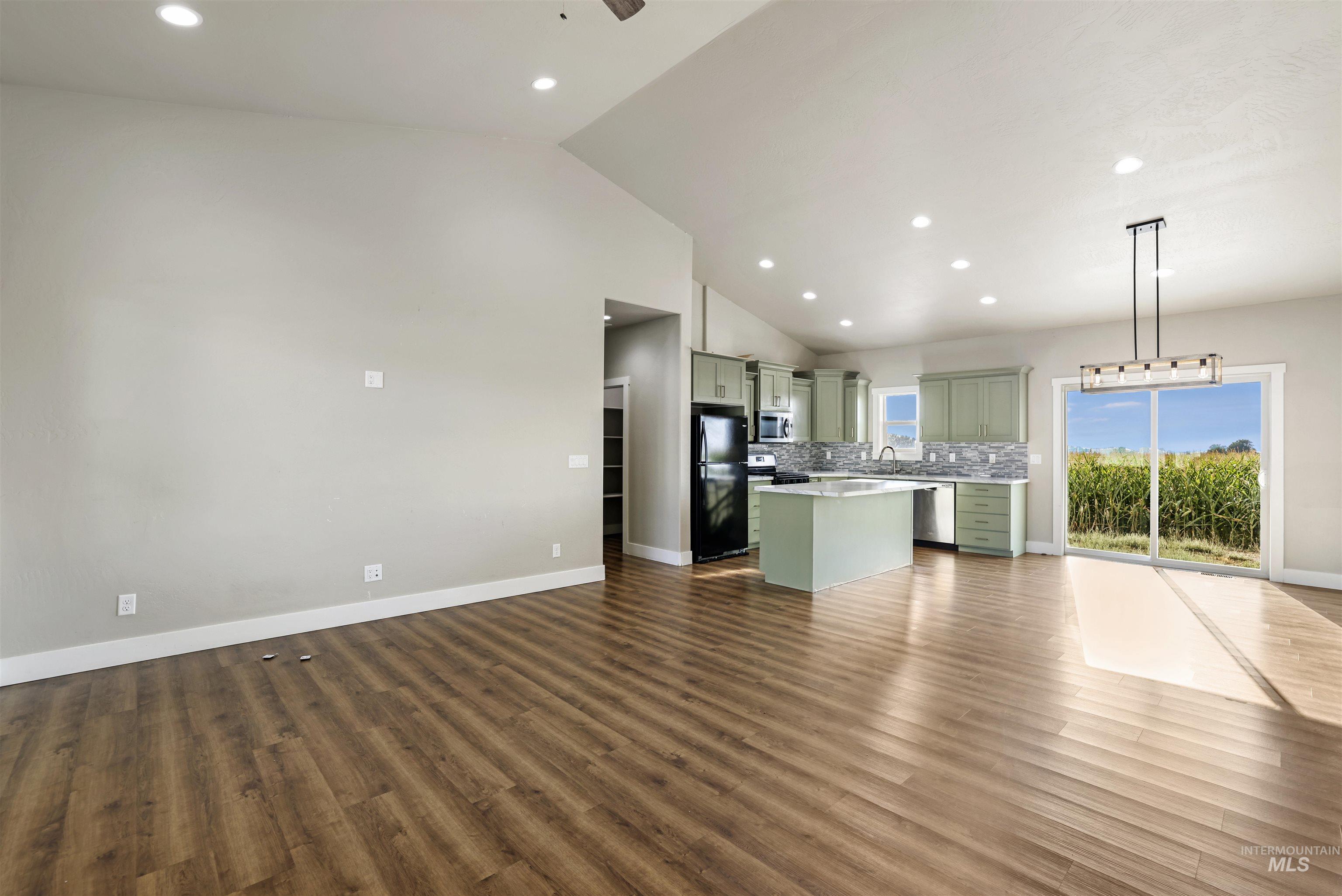 Unfurnished living room with recessed lighting, vaulted ceiling, dark wood finished floors, and ceiling fan
