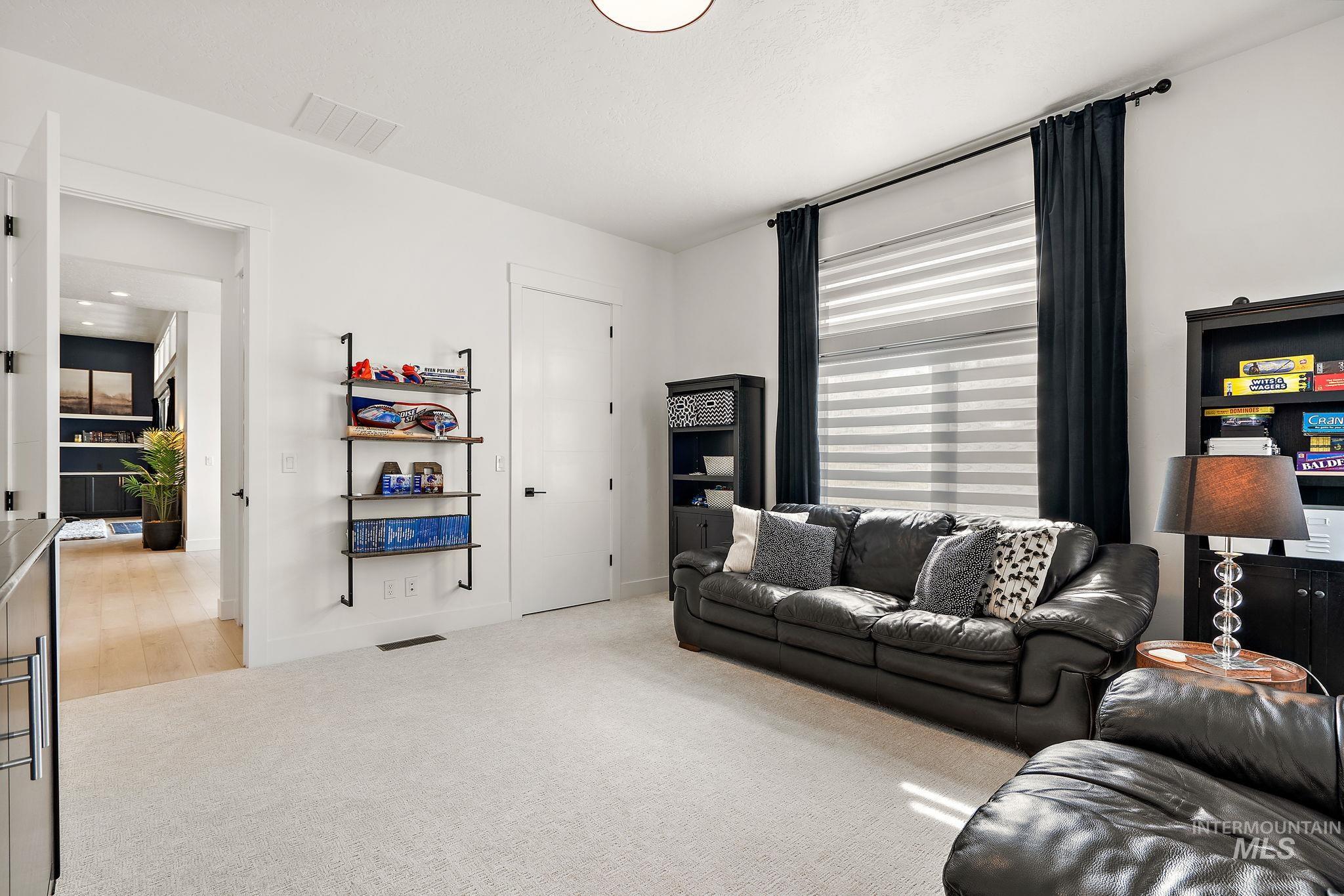 Living area with light carpet and baseboards