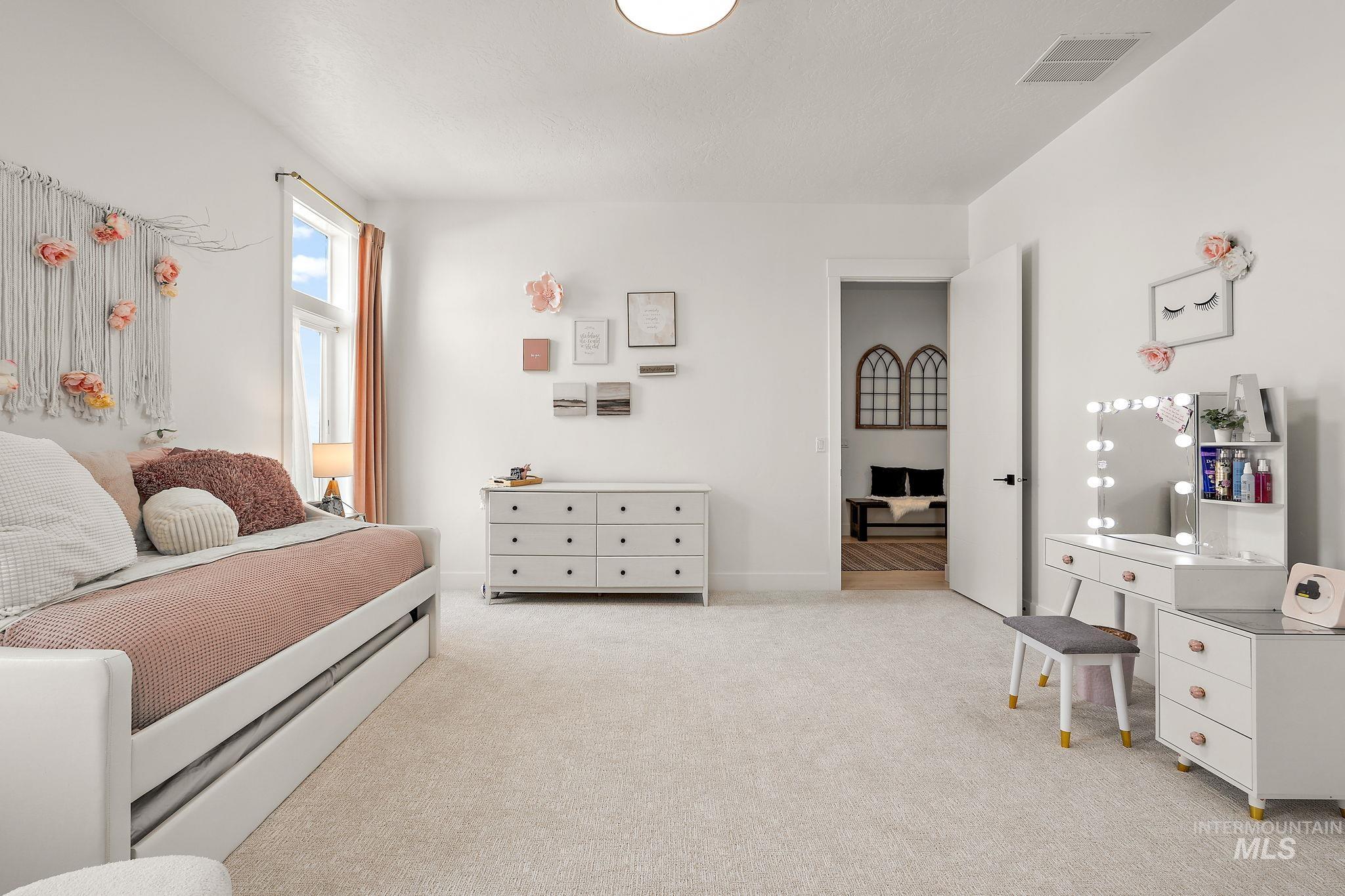 Bedroom featuring light carpet and baseboards
