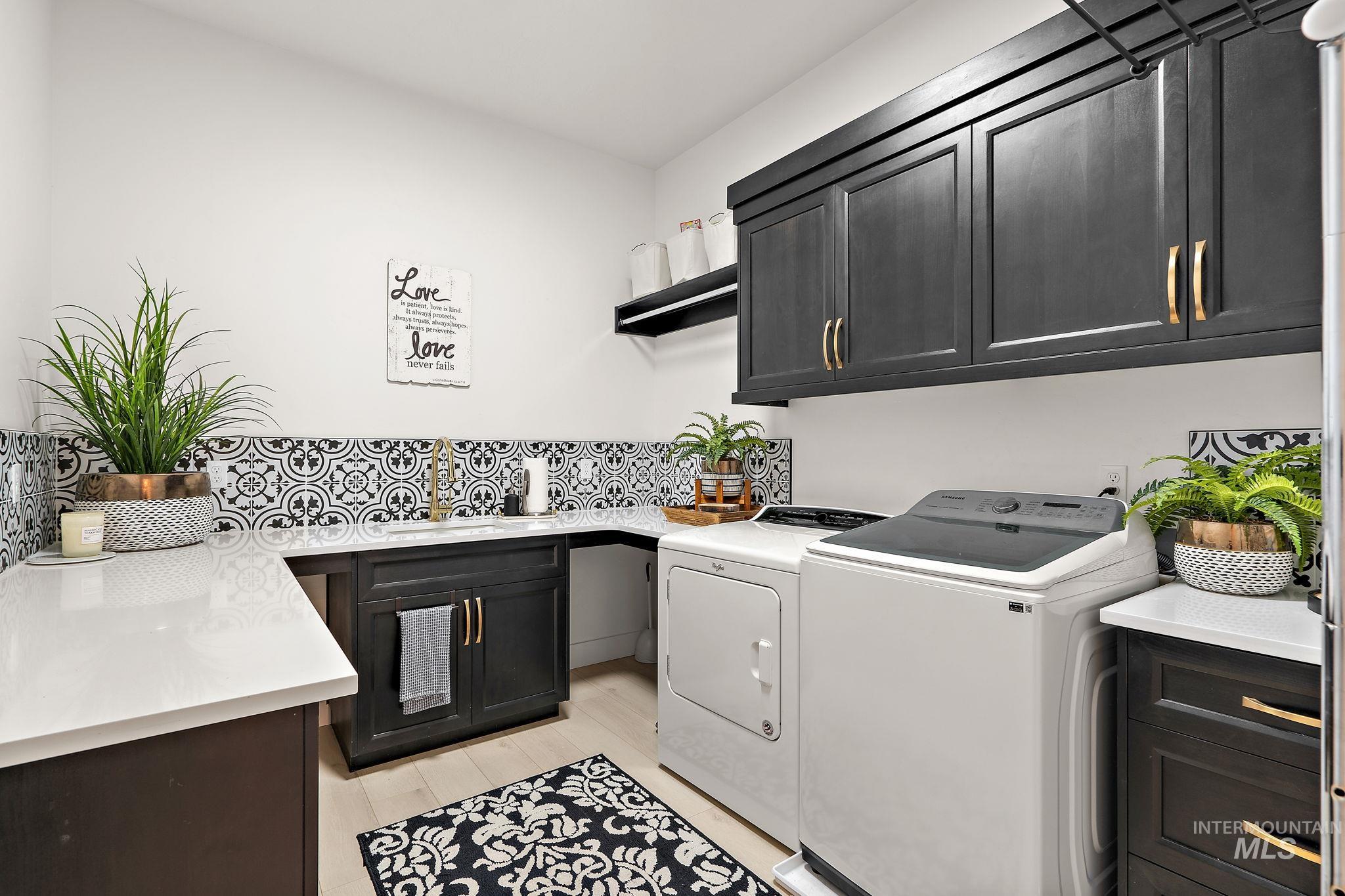 Laundry room with cabinet space, washing machine and clothes dryer, and light wood-style flooring