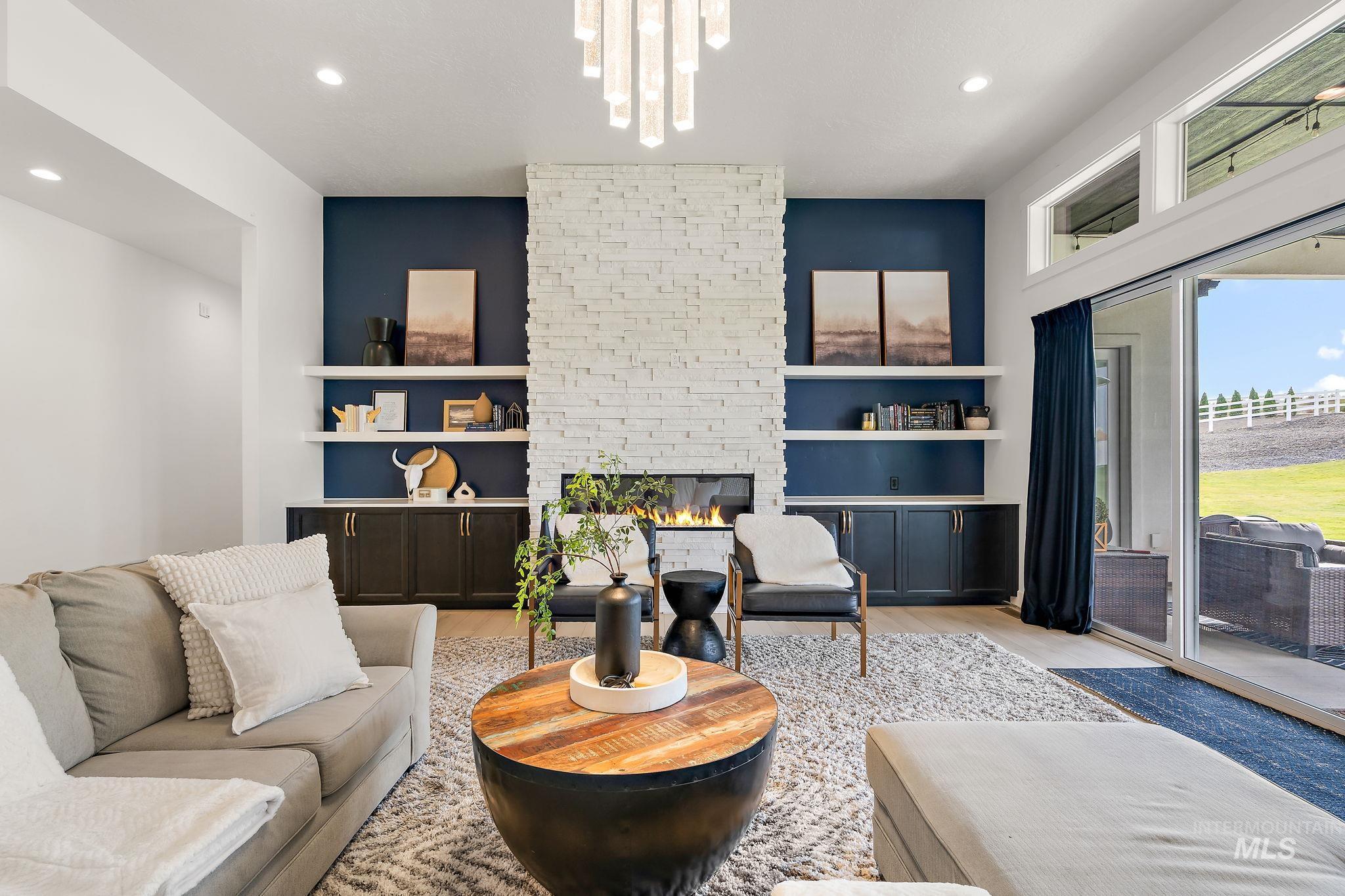 Living area with a fireplace, light wood-style flooring, recessed lighting, and a chandelier