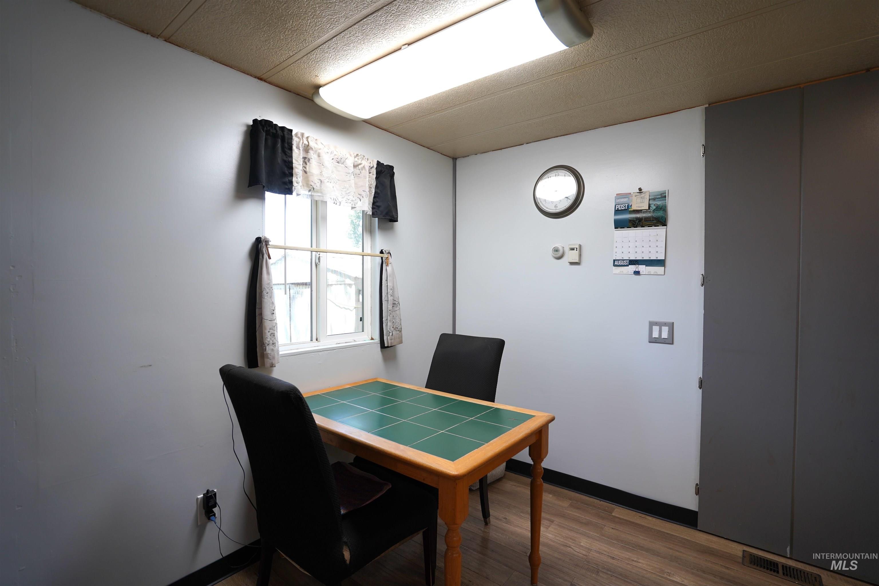 Office space with wood finished floors and a textured ceiling