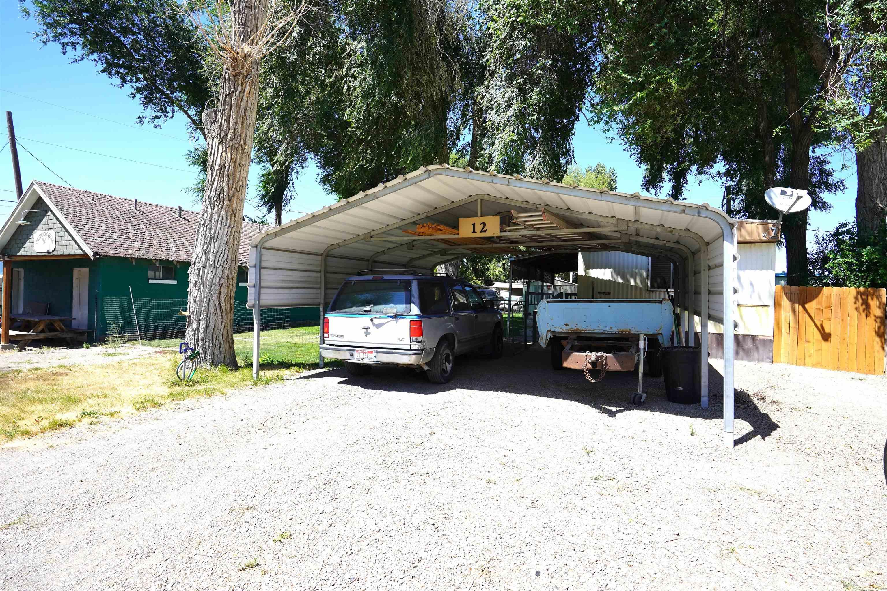 View of car parking featuring a detached carport and driveway