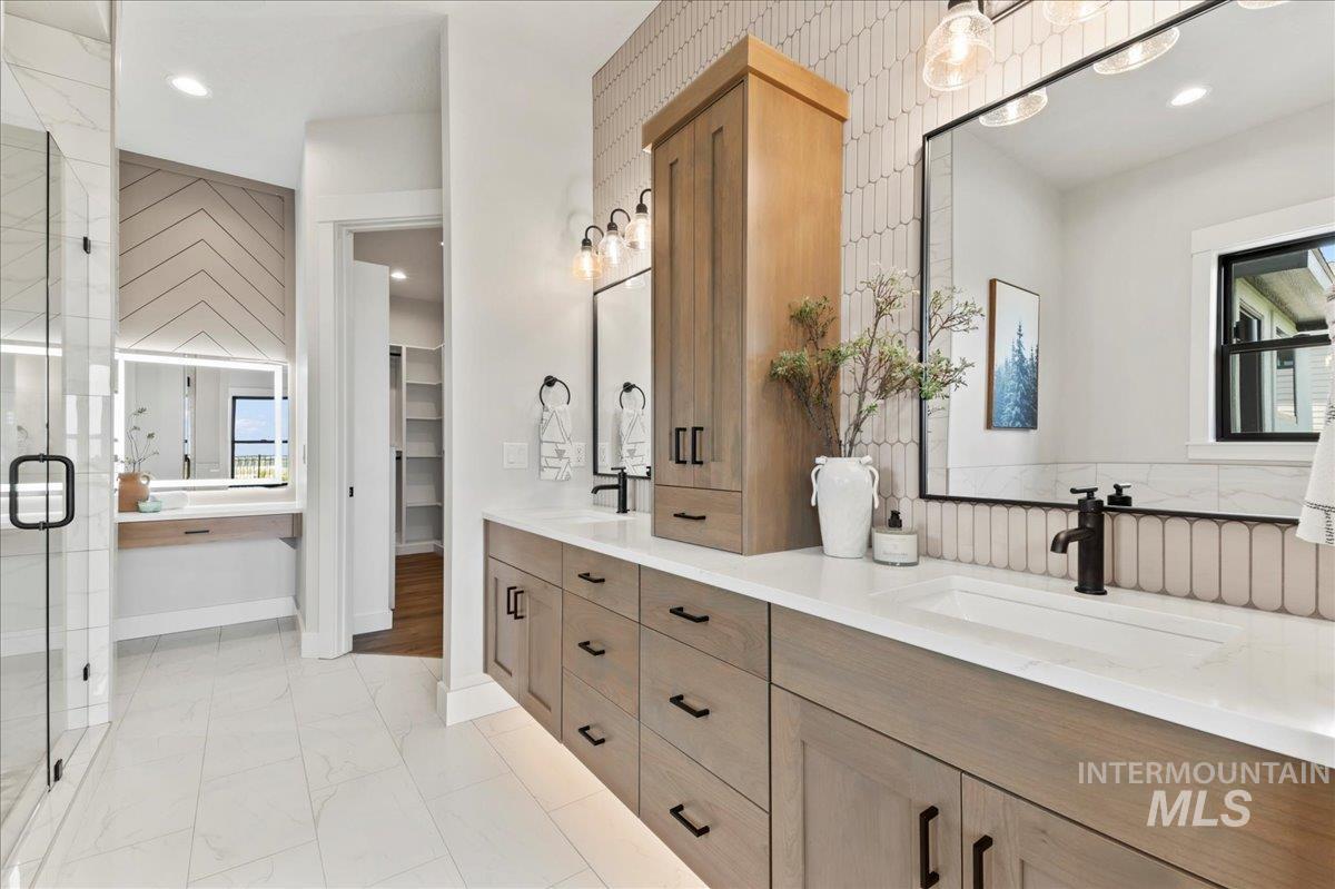 Full bath featuring recessed lighting, double vanity, light marble finish floors, a stall shower, and a spacious closet