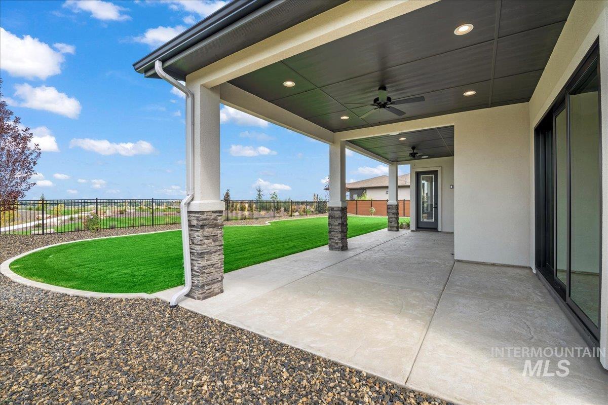 Fenced backyard featuring a patio and a ceiling fan