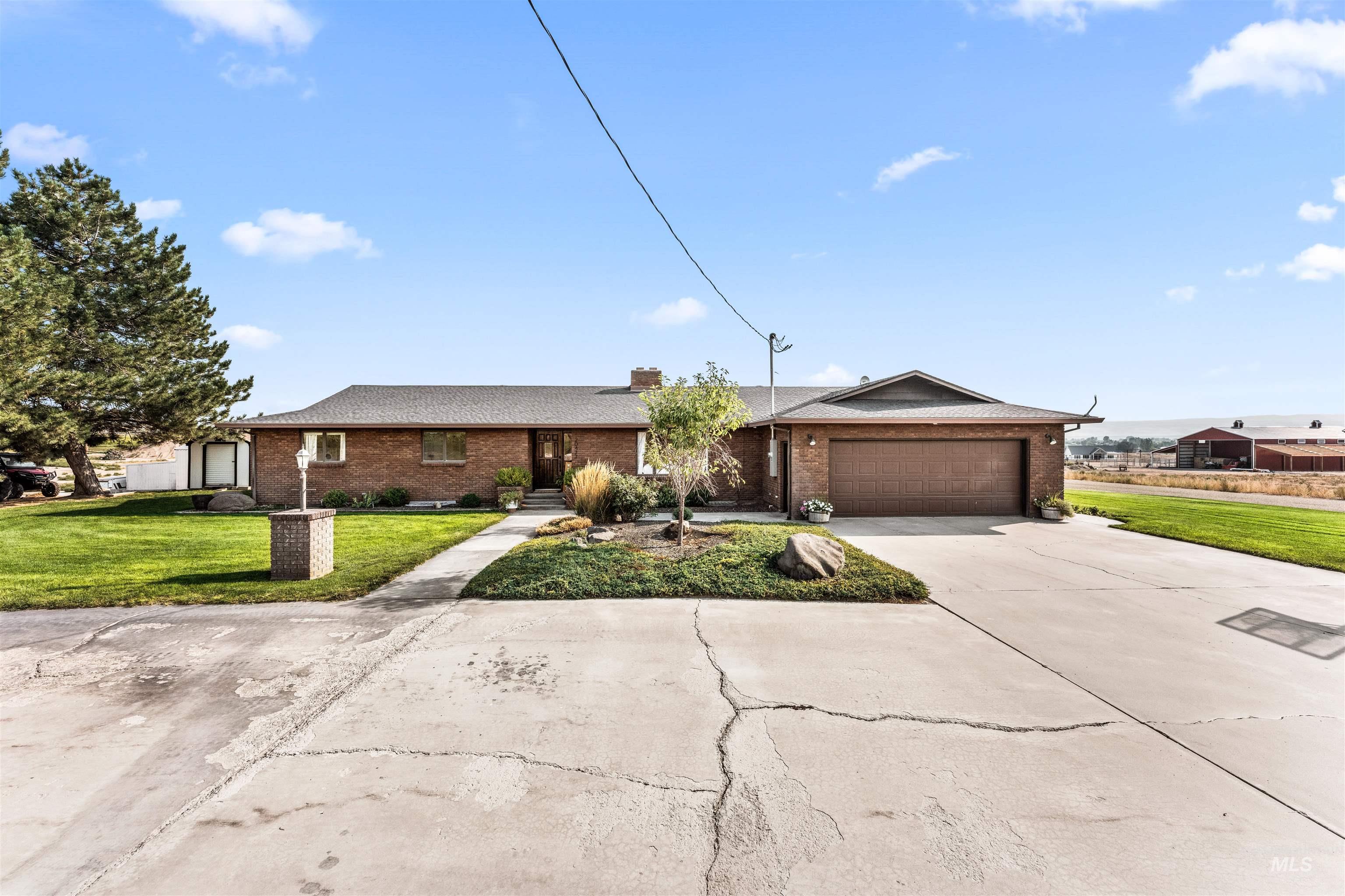 Ranch-style house featuring a front lawn, brick siding, and driveway