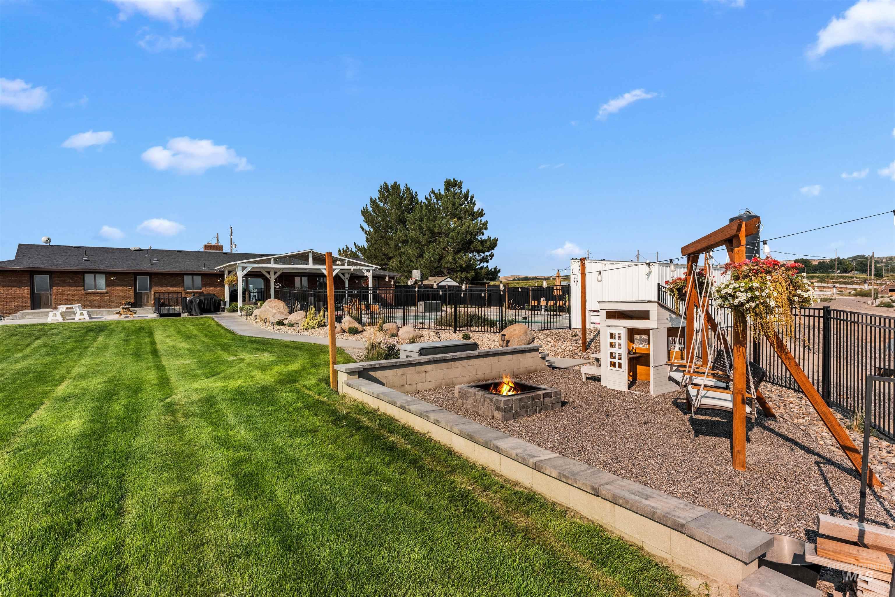View of play area featuring a patio and an outdoor fire pit
