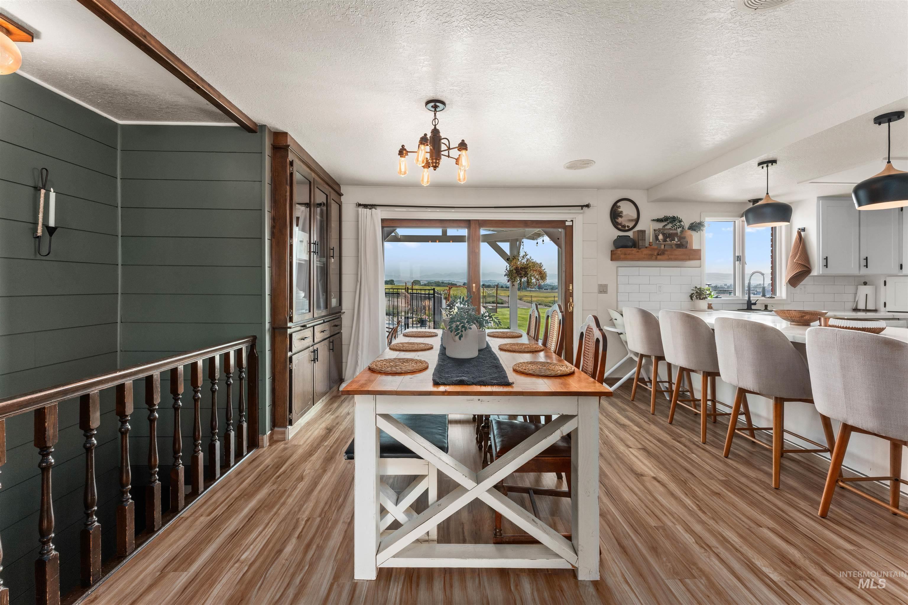 Dining area featuring a textured ceiling, light wood finished floors, and a chandelier