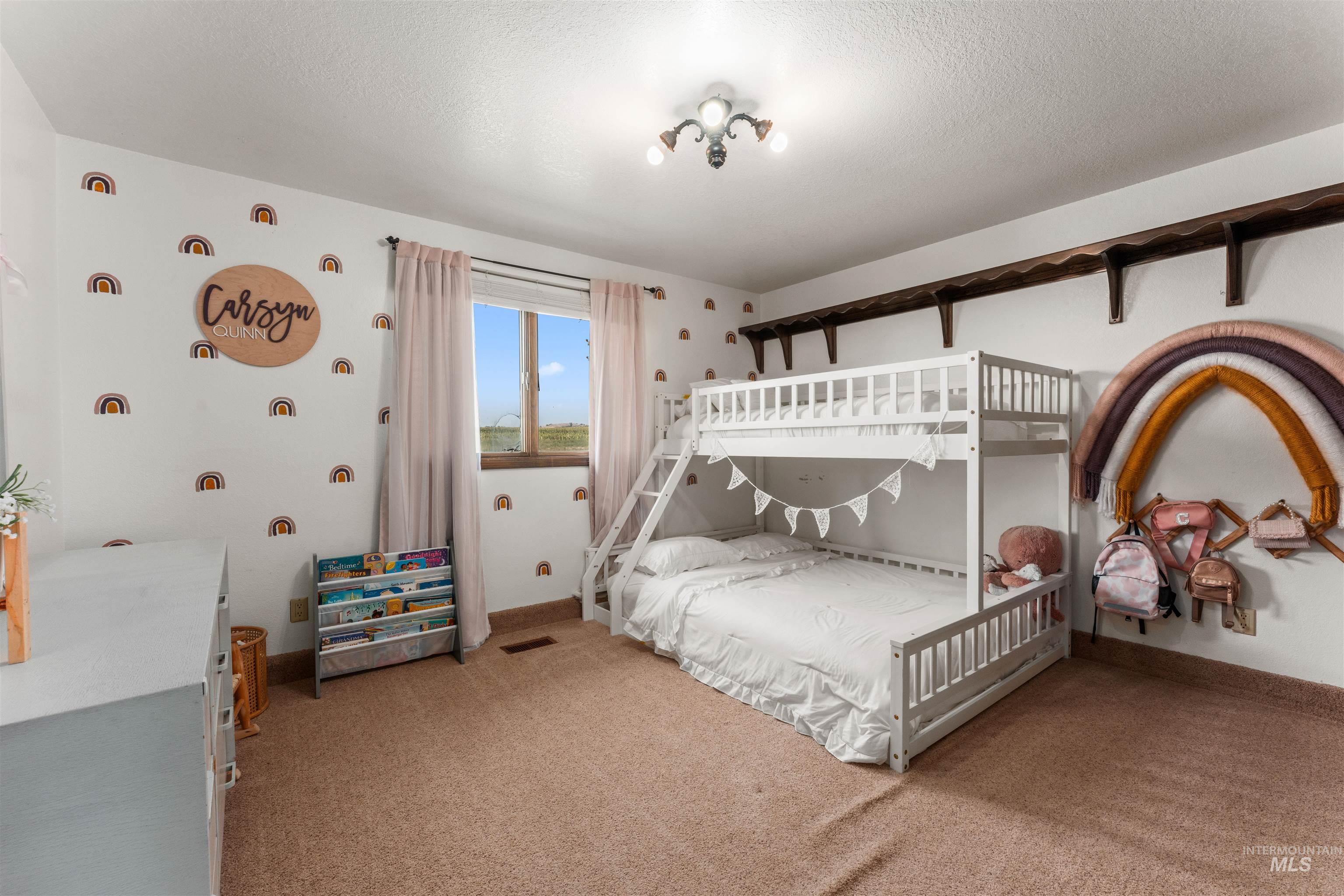 Bedroom featuring light colored carpet and a textured ceiling