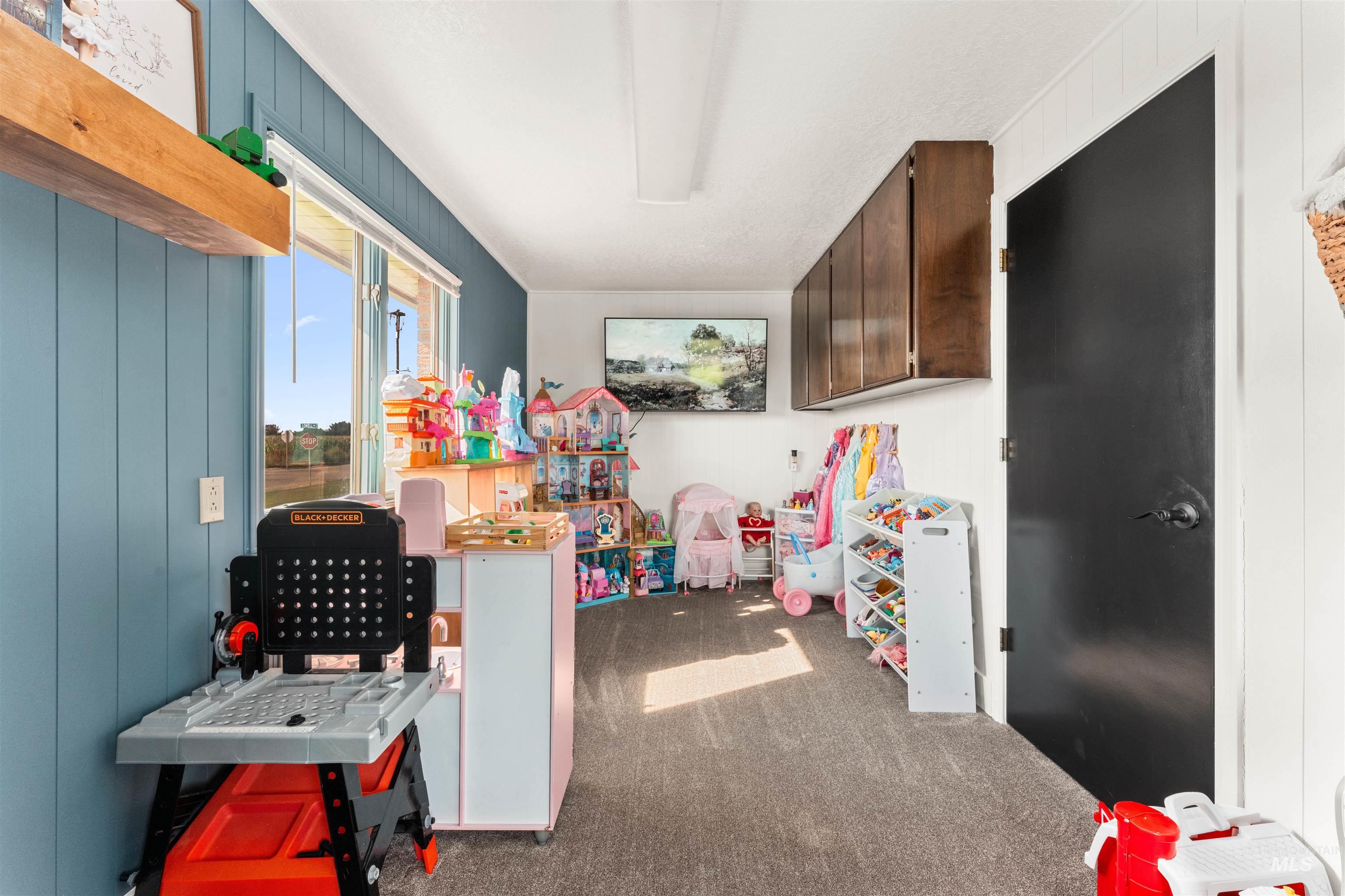 Recreation room featuring dark carpet and wooden walls