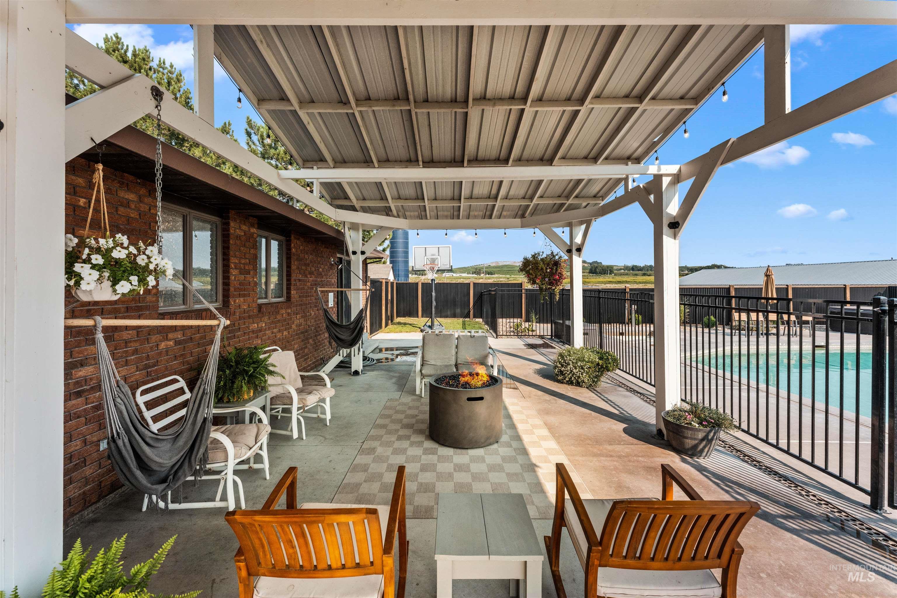 View of patio with an outdoor fire pit and a community pool