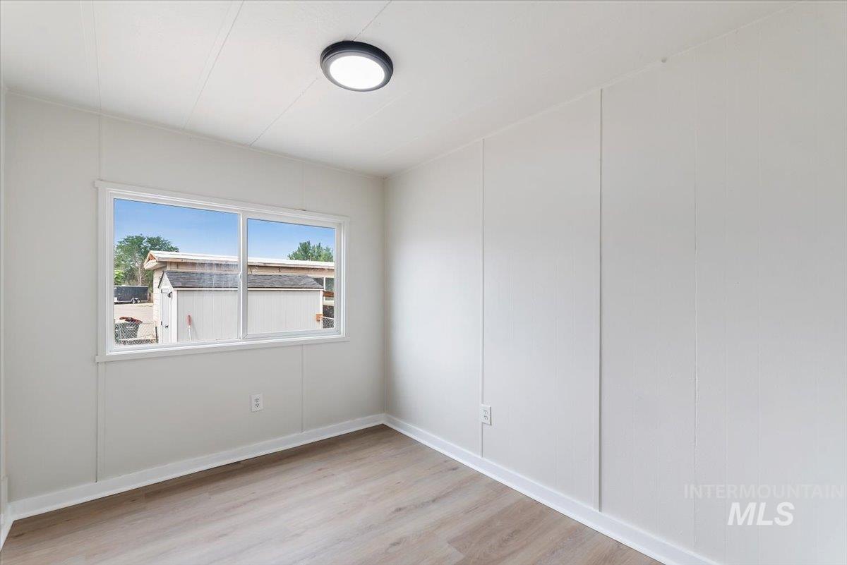 Unfurnished room with light wood-style flooring and baseboards
