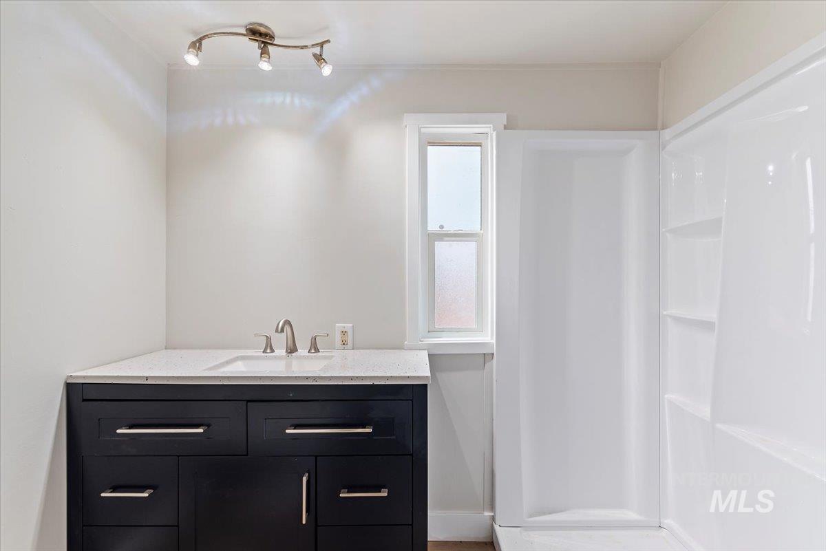 Full bathroom featuring vanity and a shower stall