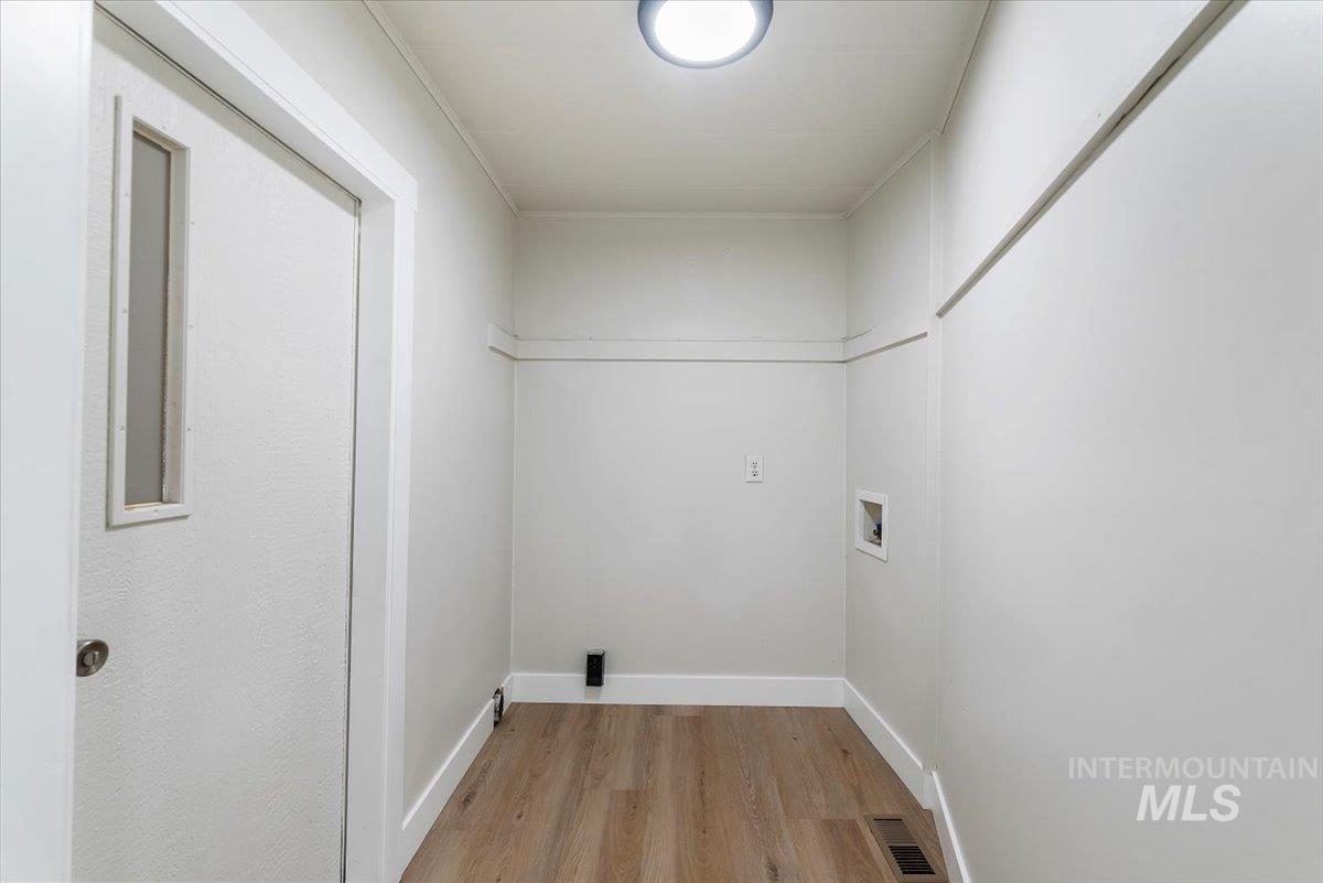 Washroom featuring light wood-style flooring and hookup for a washing machine