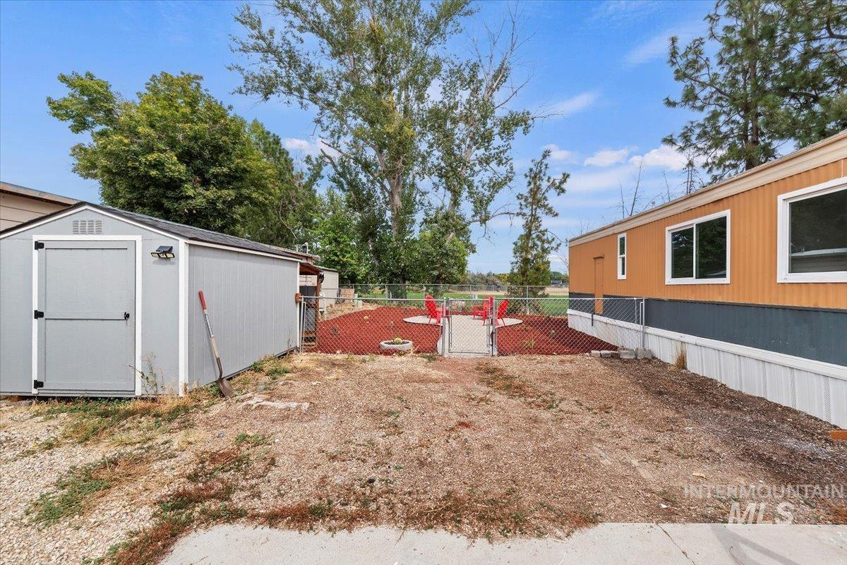 View of yard featuring a gate and a storage shed