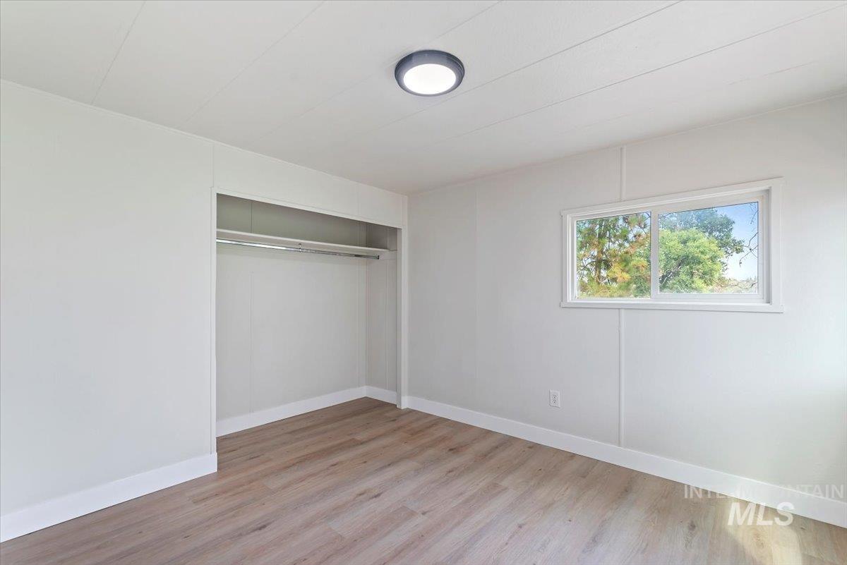 Unfurnished bedroom featuring light wood-style floors and a closet