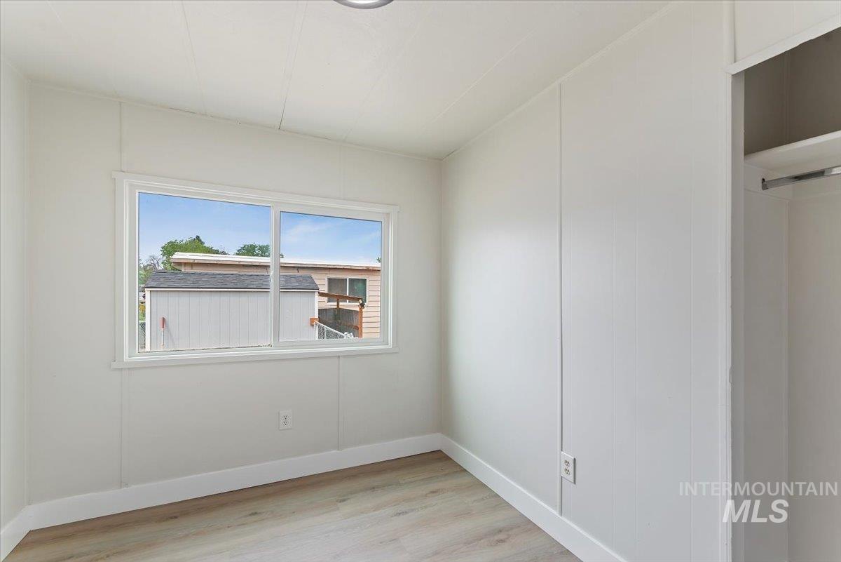 Unfurnished bedroom with light wood finished floors and baseboards
