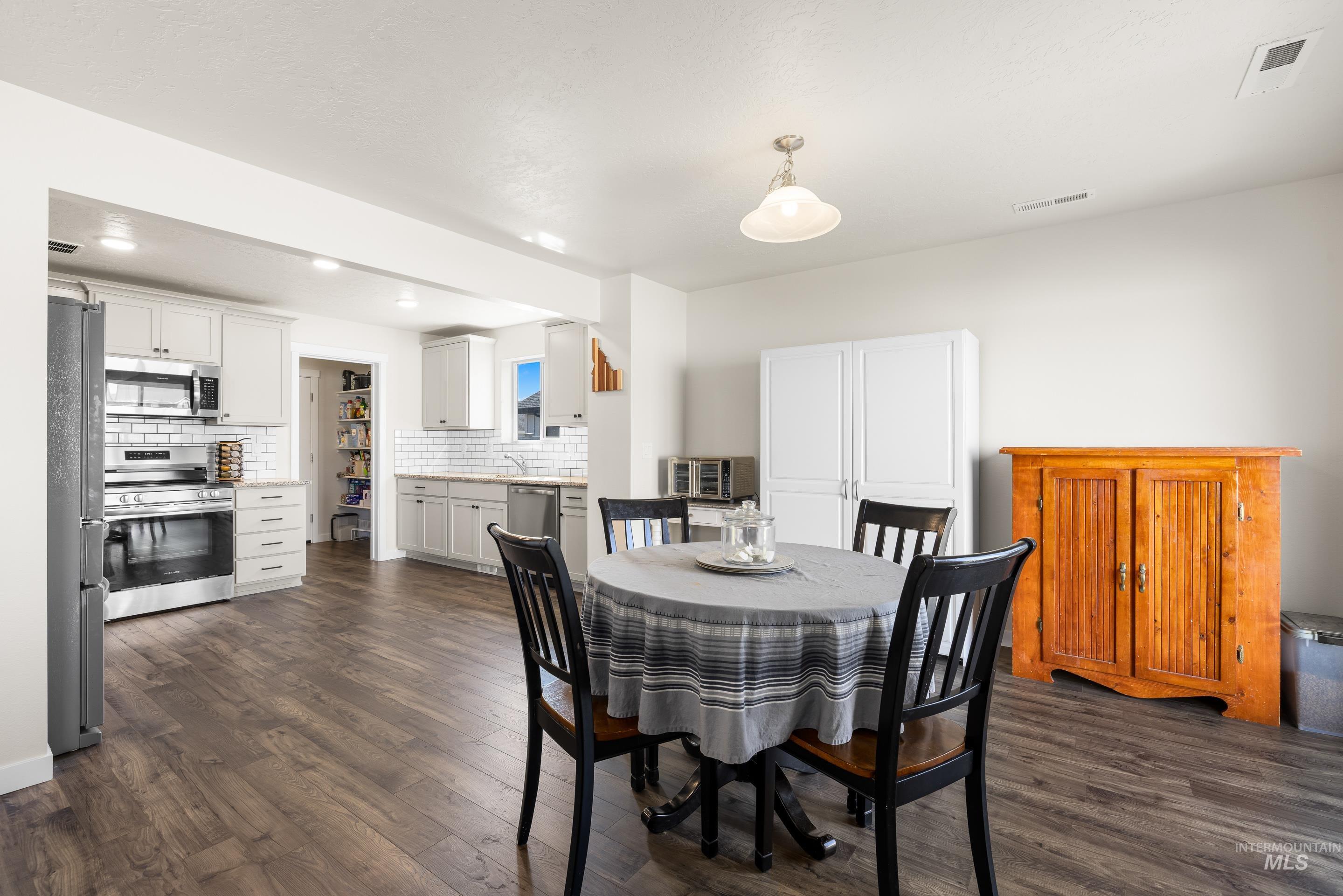 Dining room featuring dark wood-type flooring