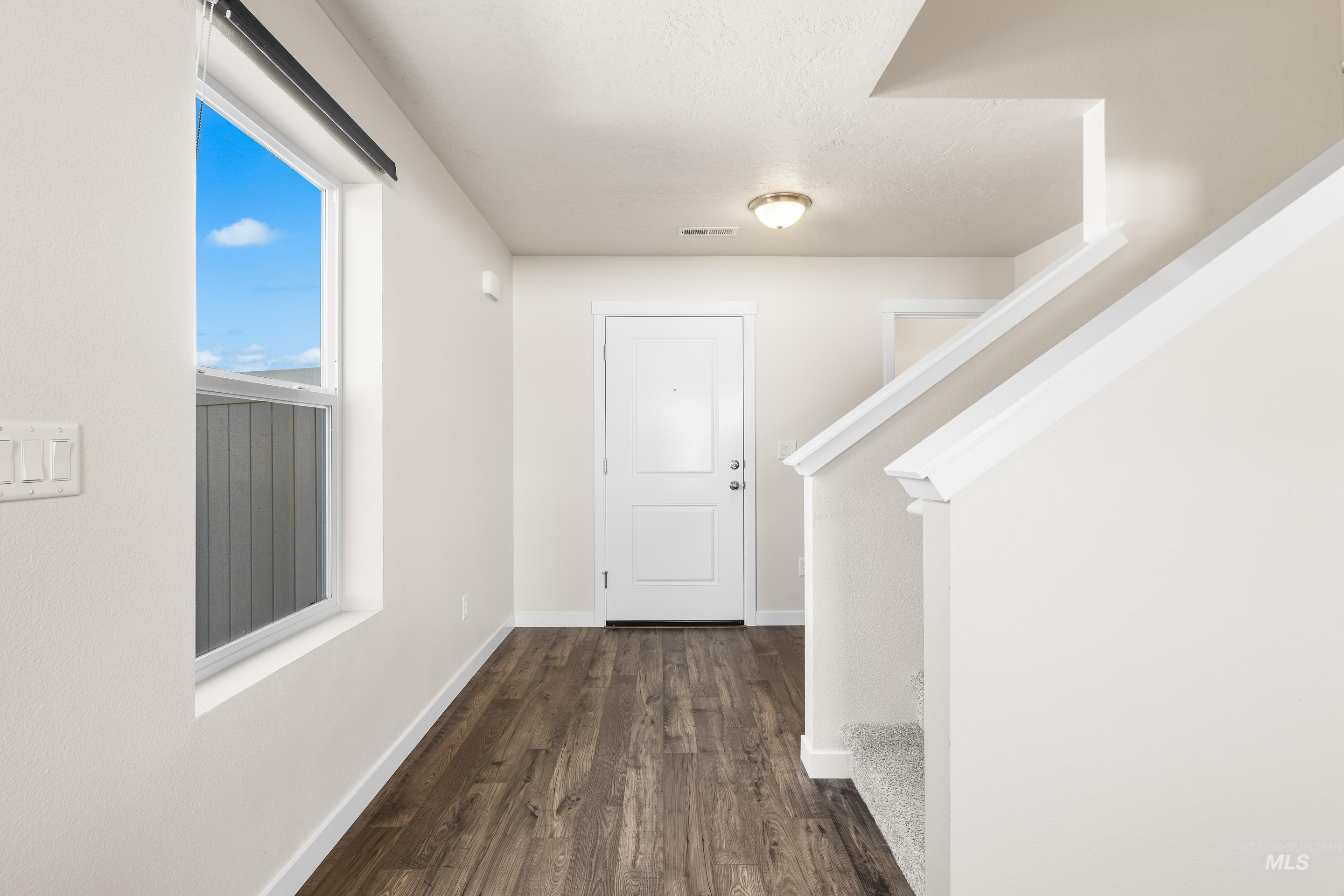 Hallway with dark wood-style flooring and stairway