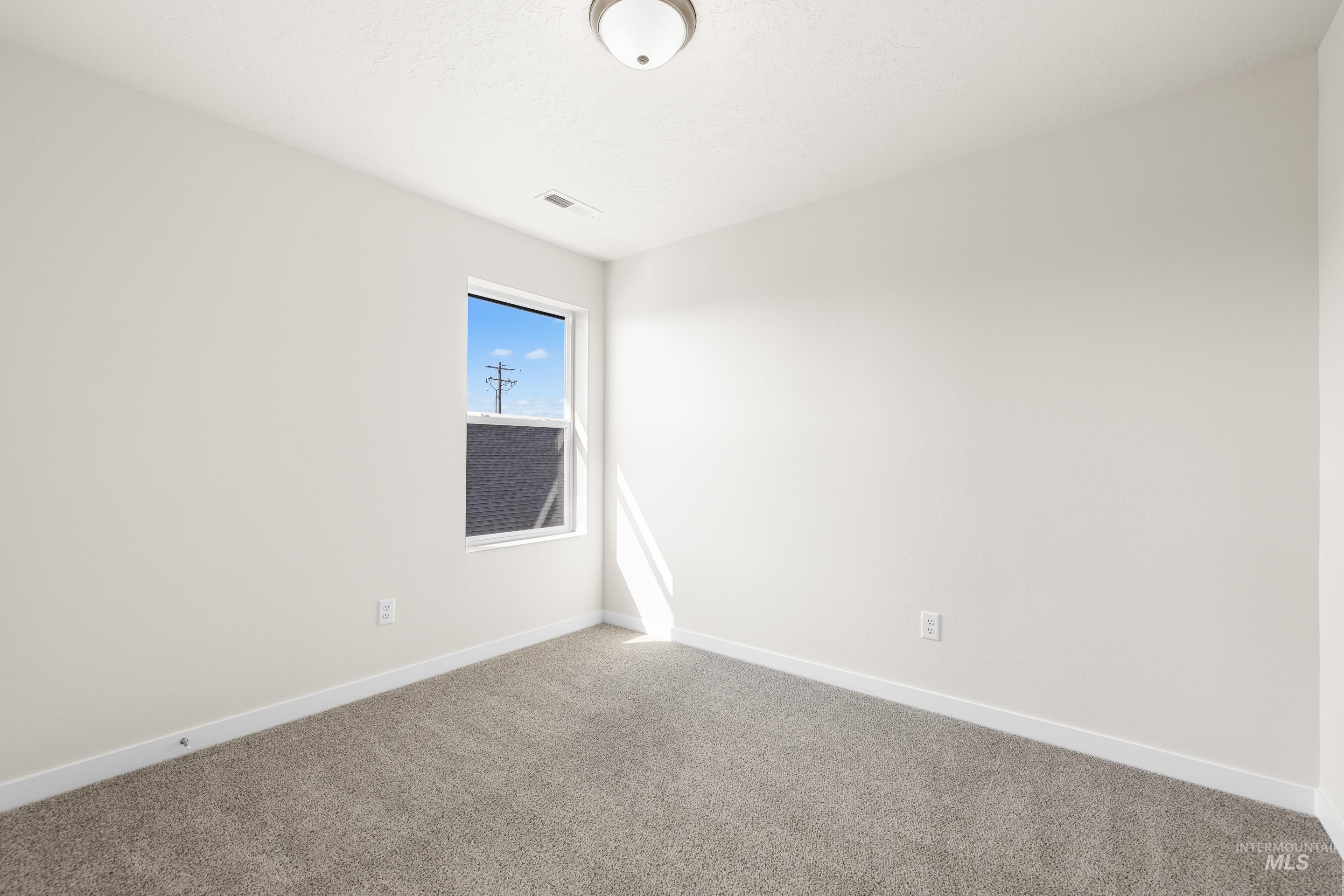 Carpeted spare room with baseboards