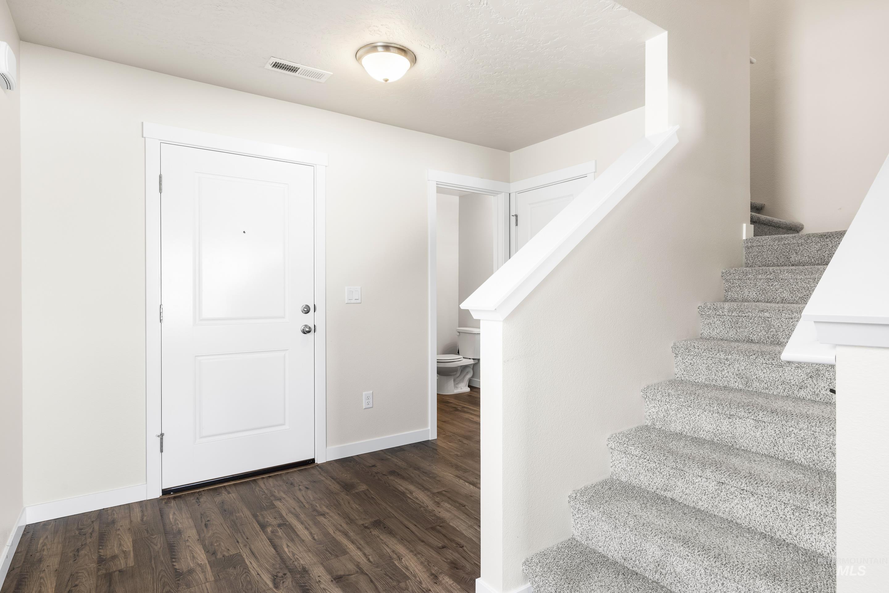 Foyer featuring stairway and dark wood-style flooring