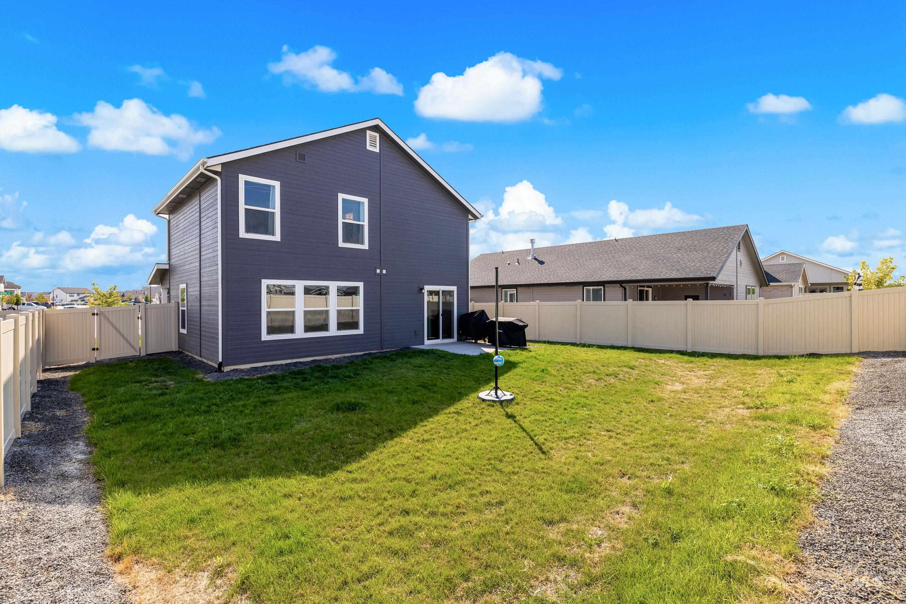 Rear view of property featuring a gate, a fenced backyard, and a patio