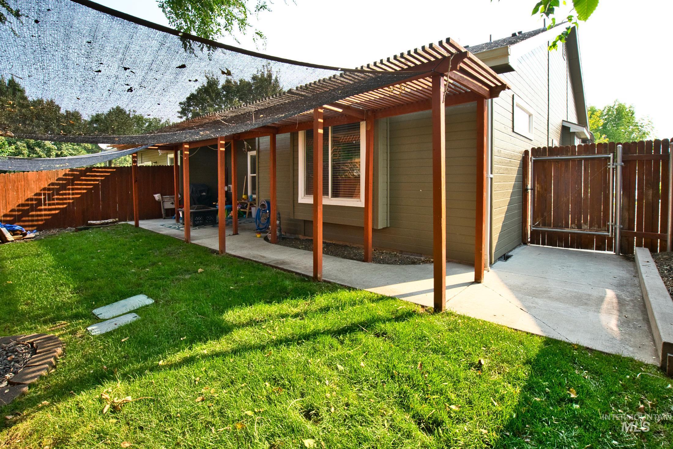 Back of property with a patio area, a pergola, and a gate