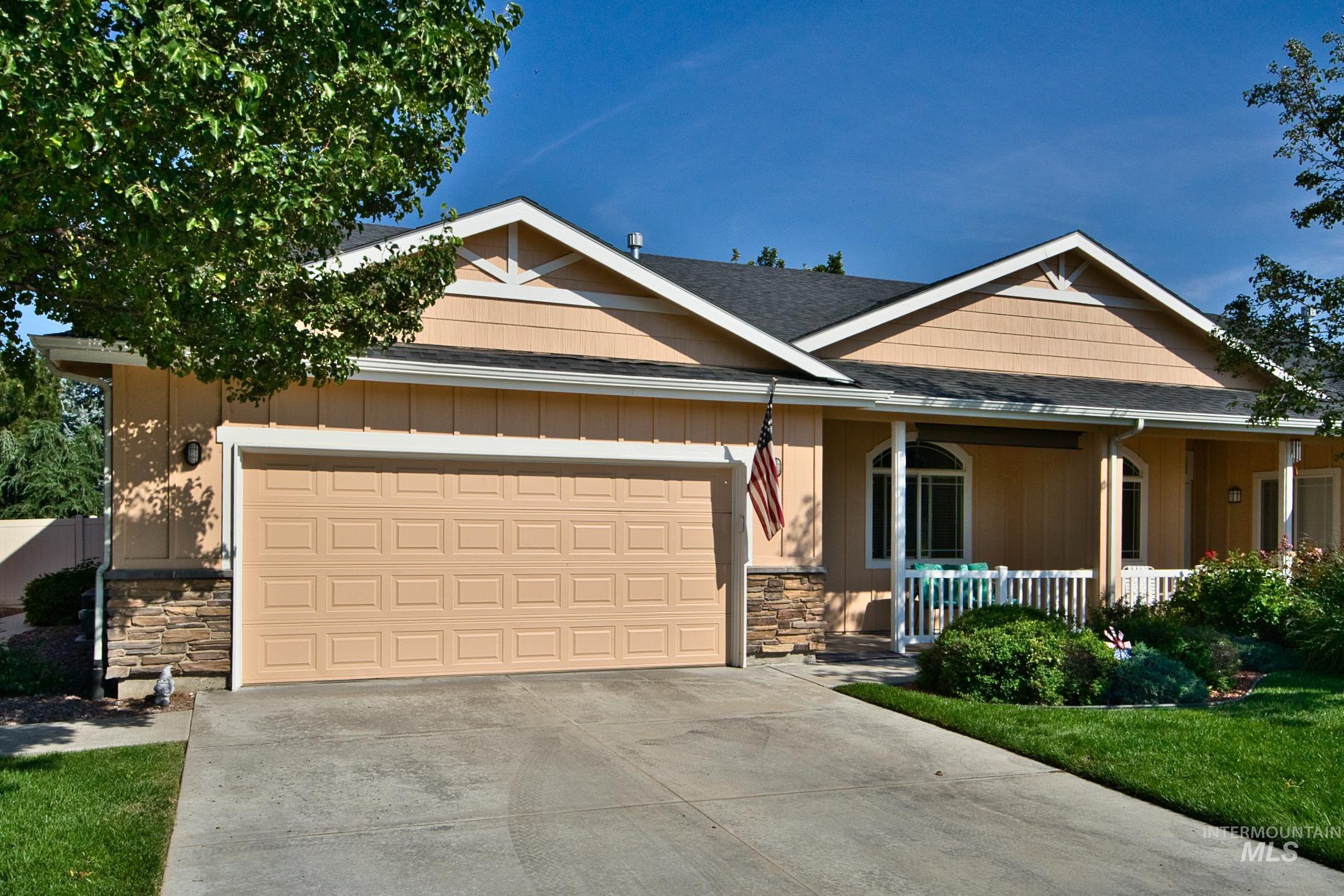View of front of house with stone siding, concrete driveway, a garage, and roof with shingles