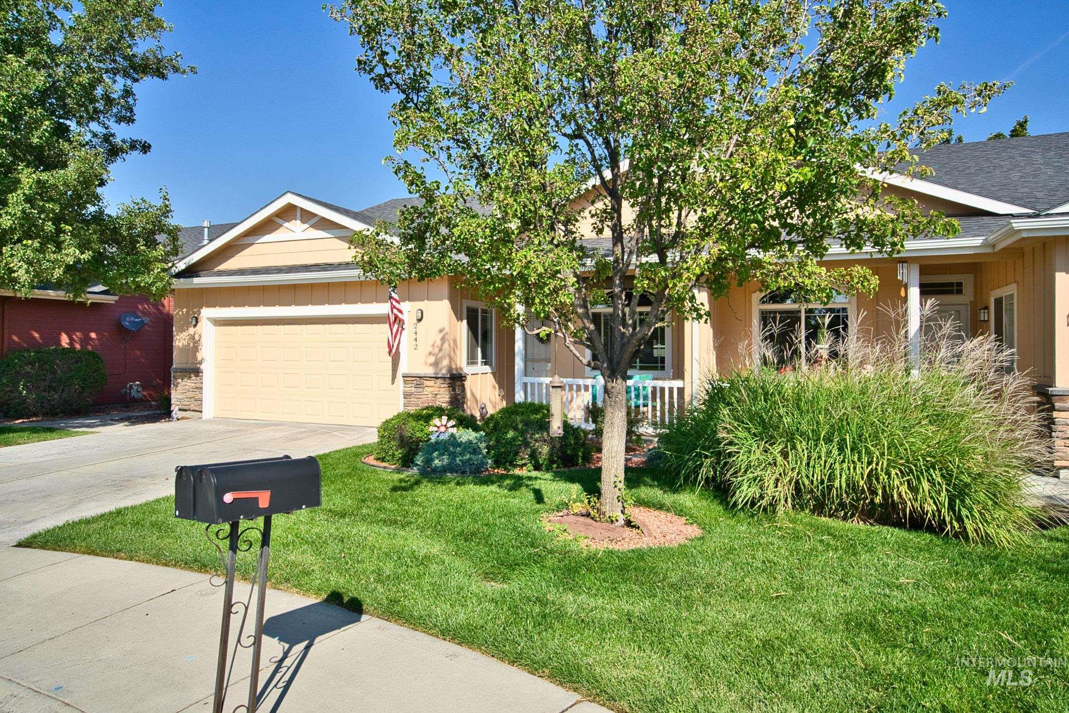 View of front facade featuring concrete driveway, a front lawn, an attached garage, and roof with shingles