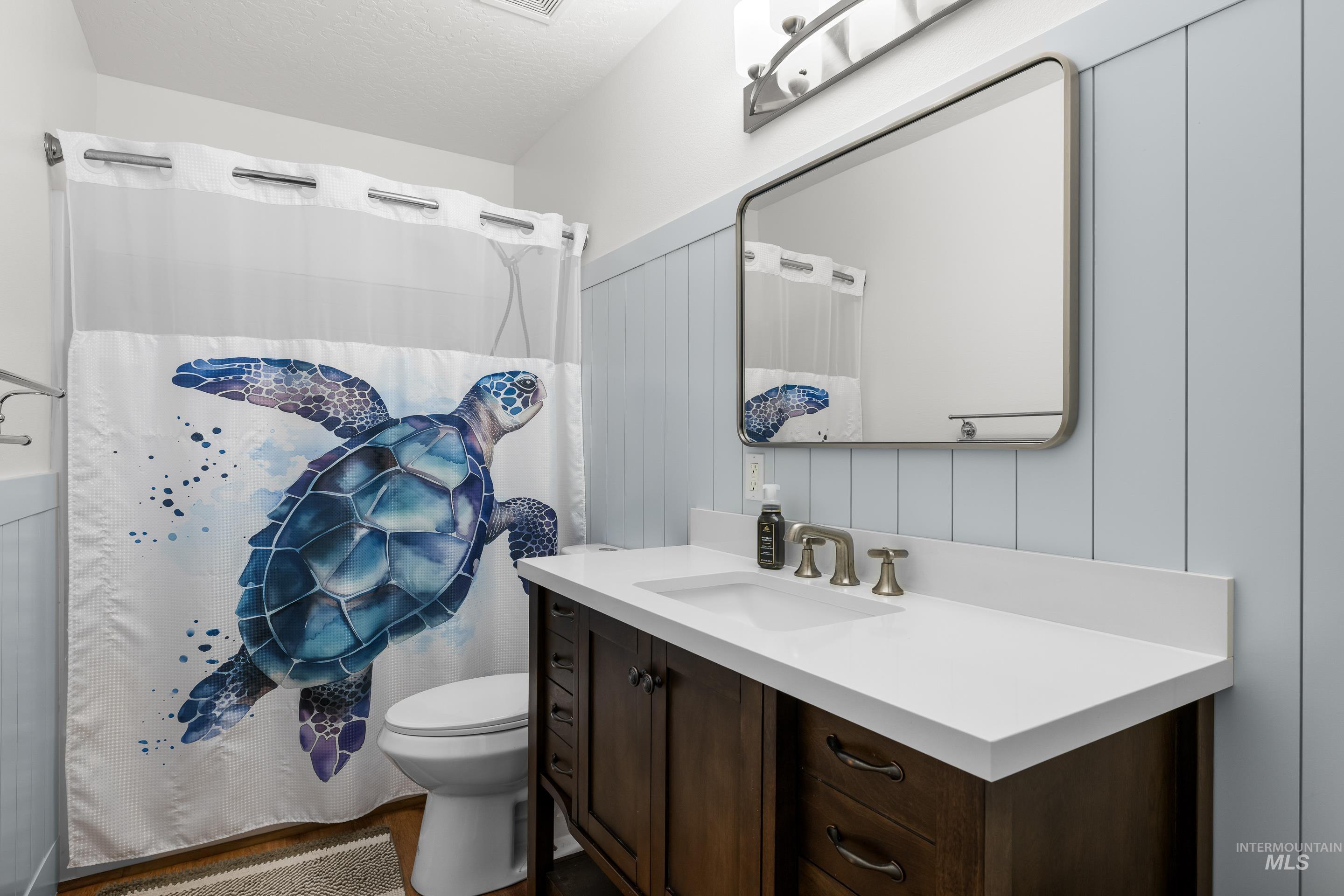 Full bath featuring vanity, a textured ceiling, and a shower with shower curtain