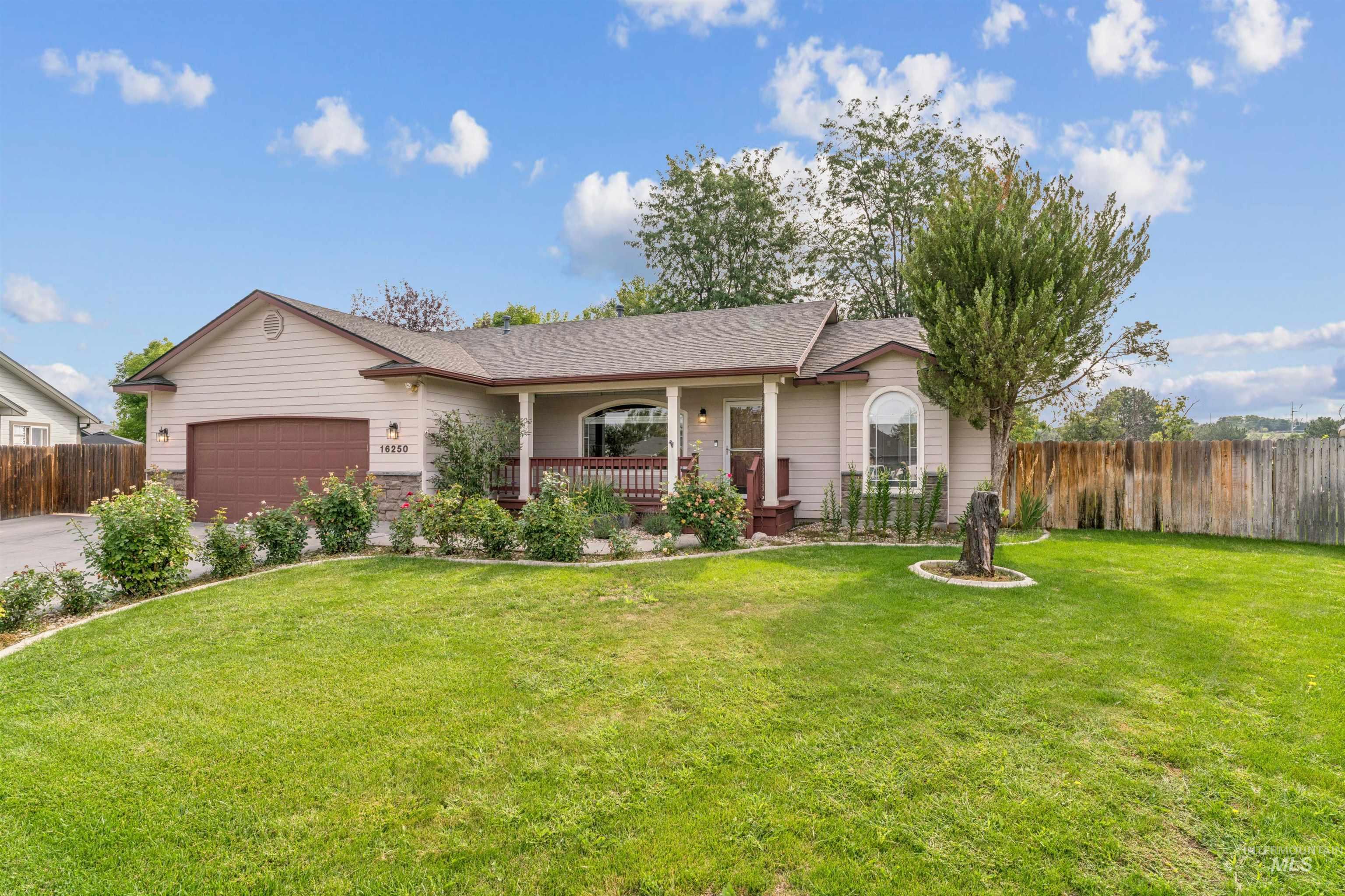 Ranch-style home featuring a porch, a shingled roof, and a garage