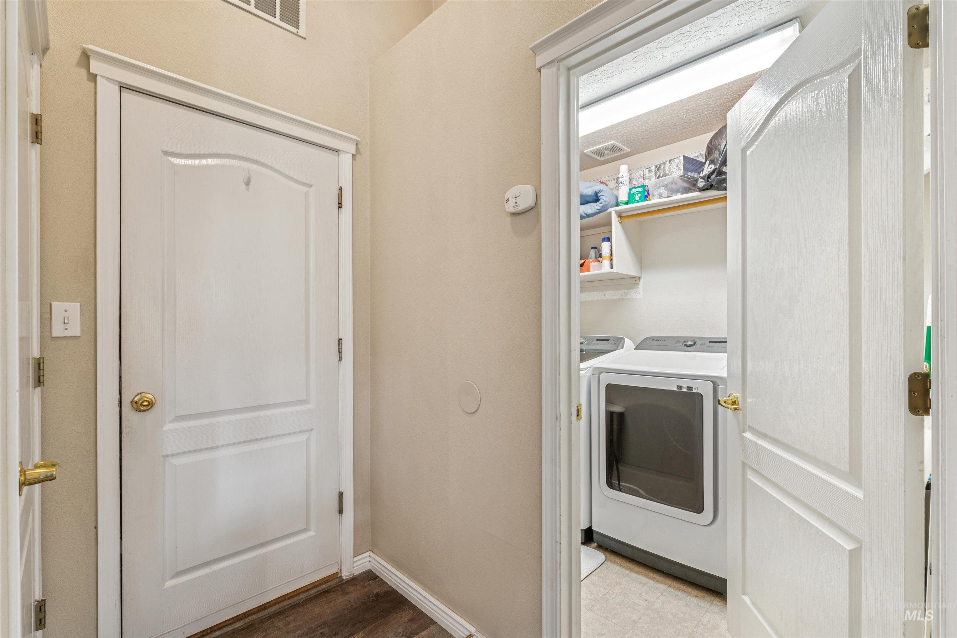 Washroom featuring independent washer and dryer and wood finished floors