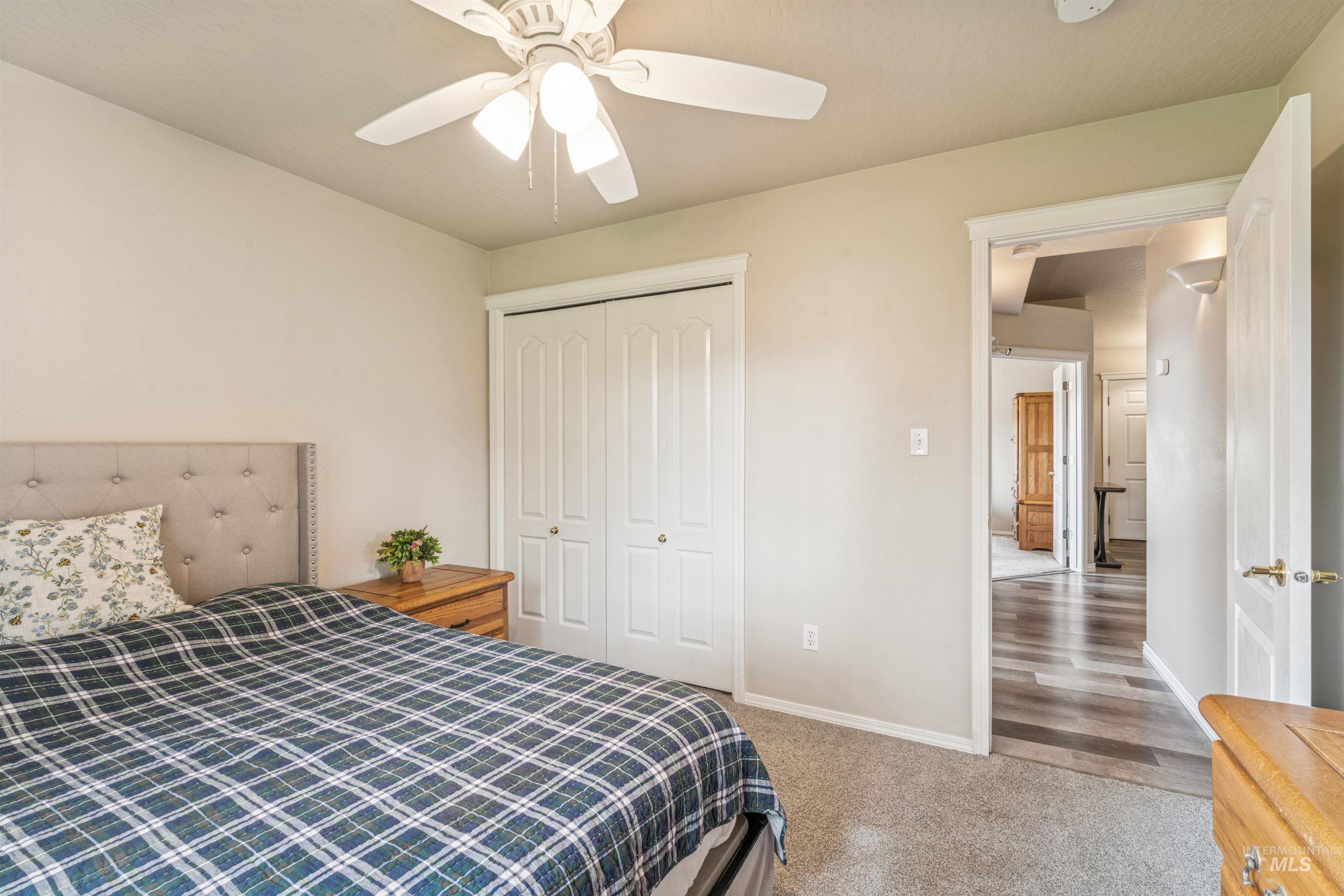 Bedroom with light carpet, a closet, and ceiling fan