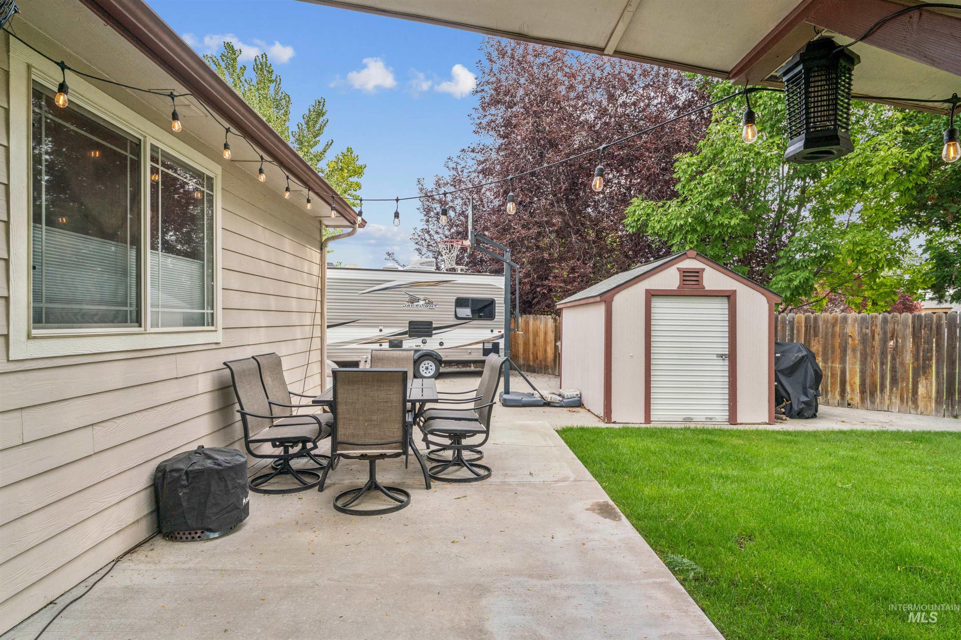 View of patio featuring a storage unit, grilling area, and outdoor dining space