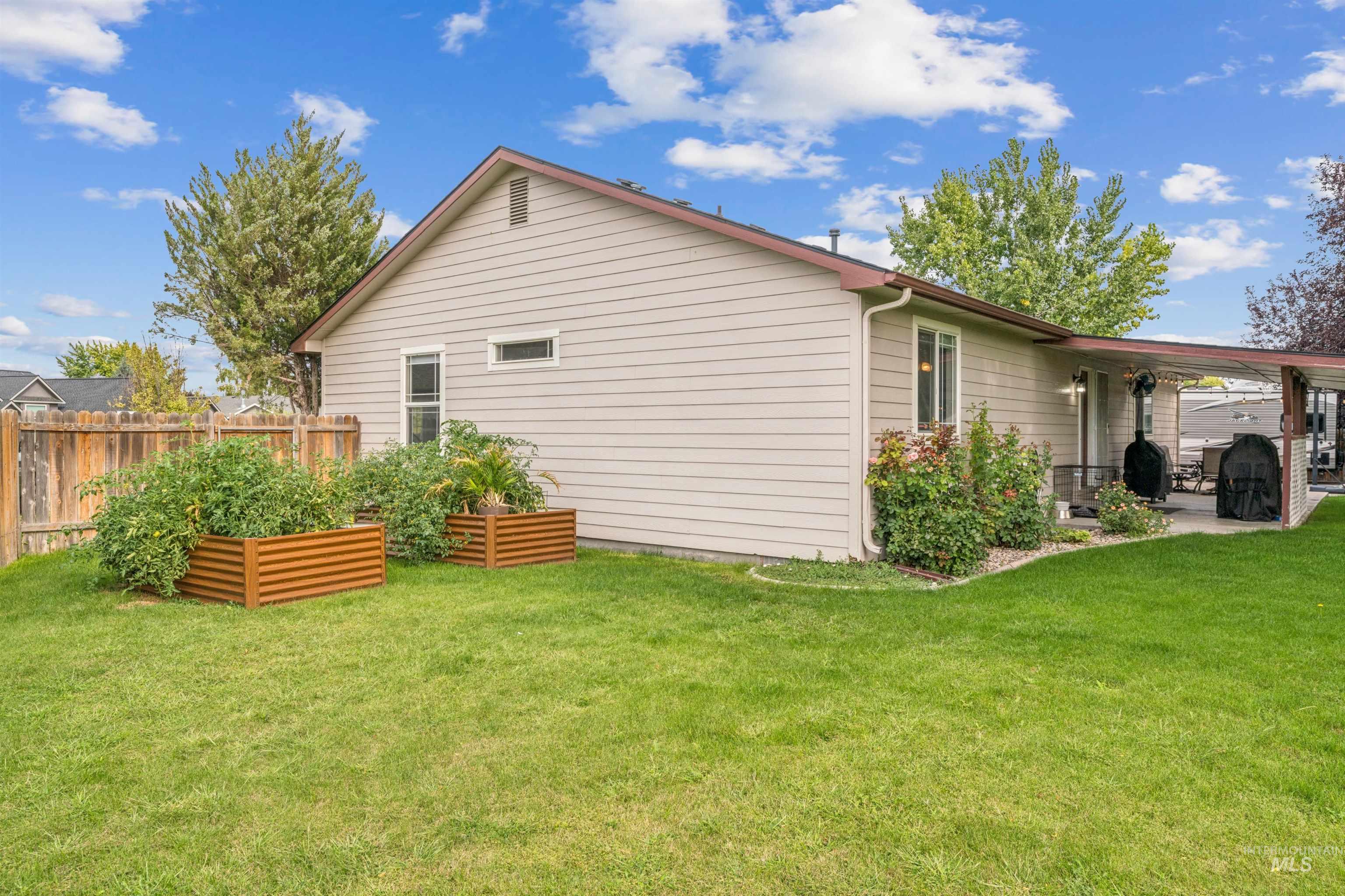 Rear view of house featuring a patio and a garden