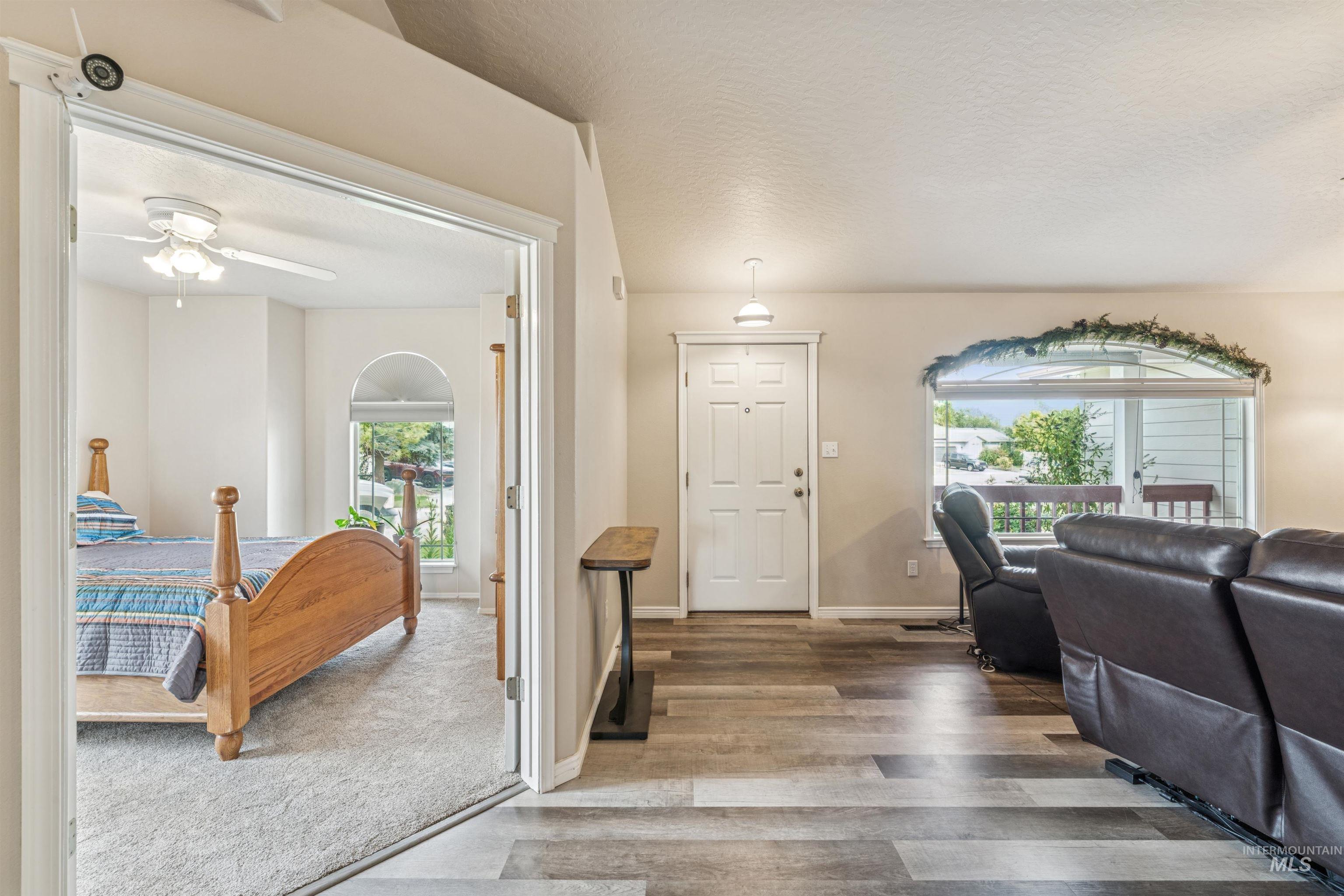 Living room with healthy amount of natural light, wood finished floors, a textured ceiling, and ceiling fan