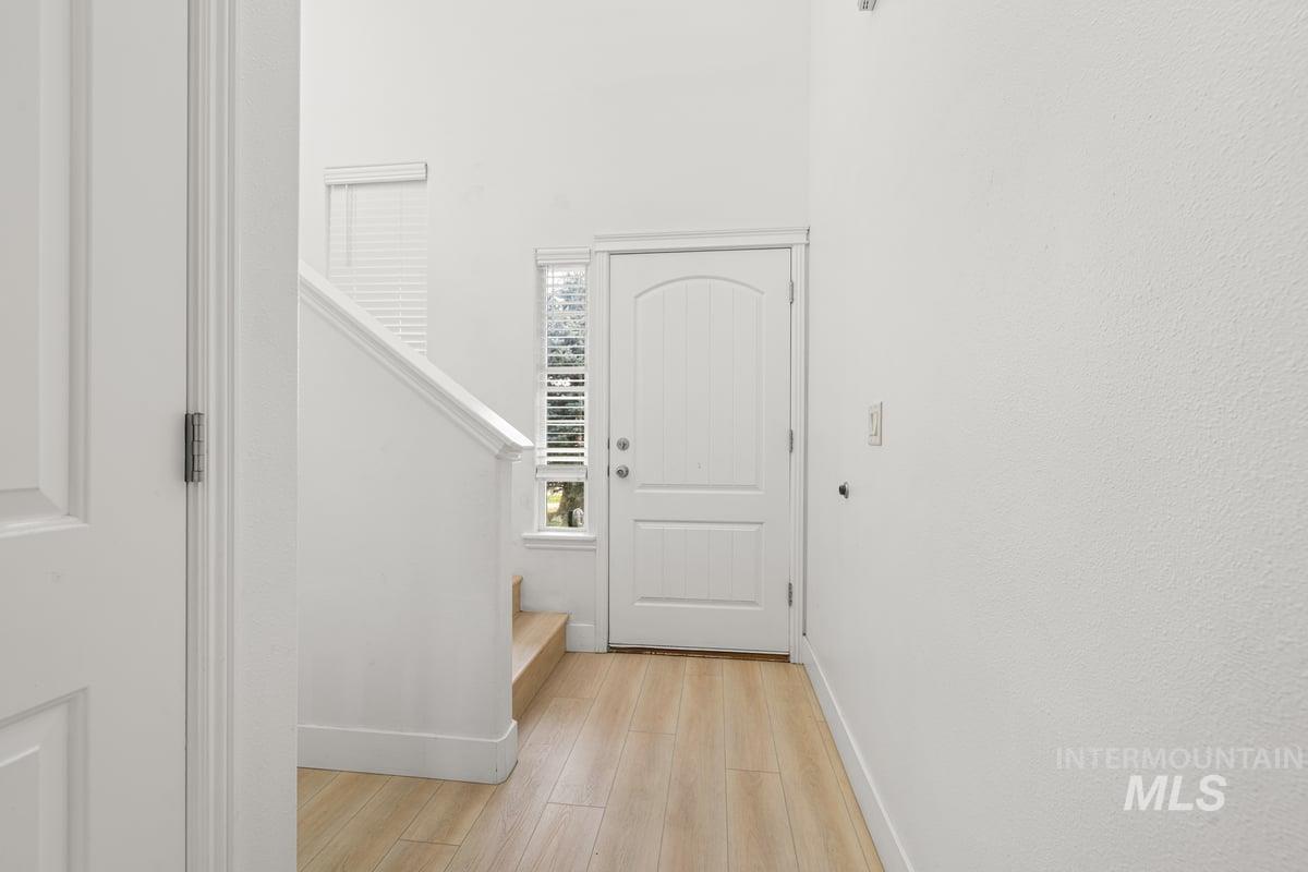 Entryway with light wood finished floors and stairway