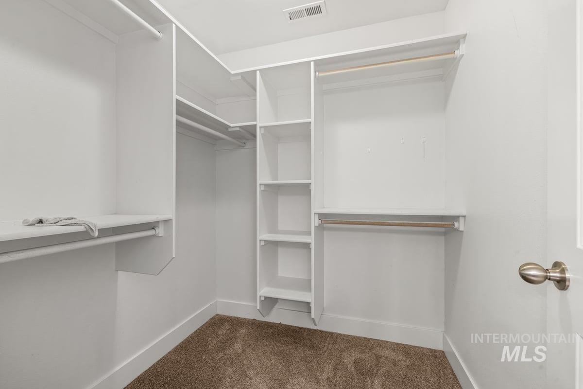 Walk in closet with dark carpet