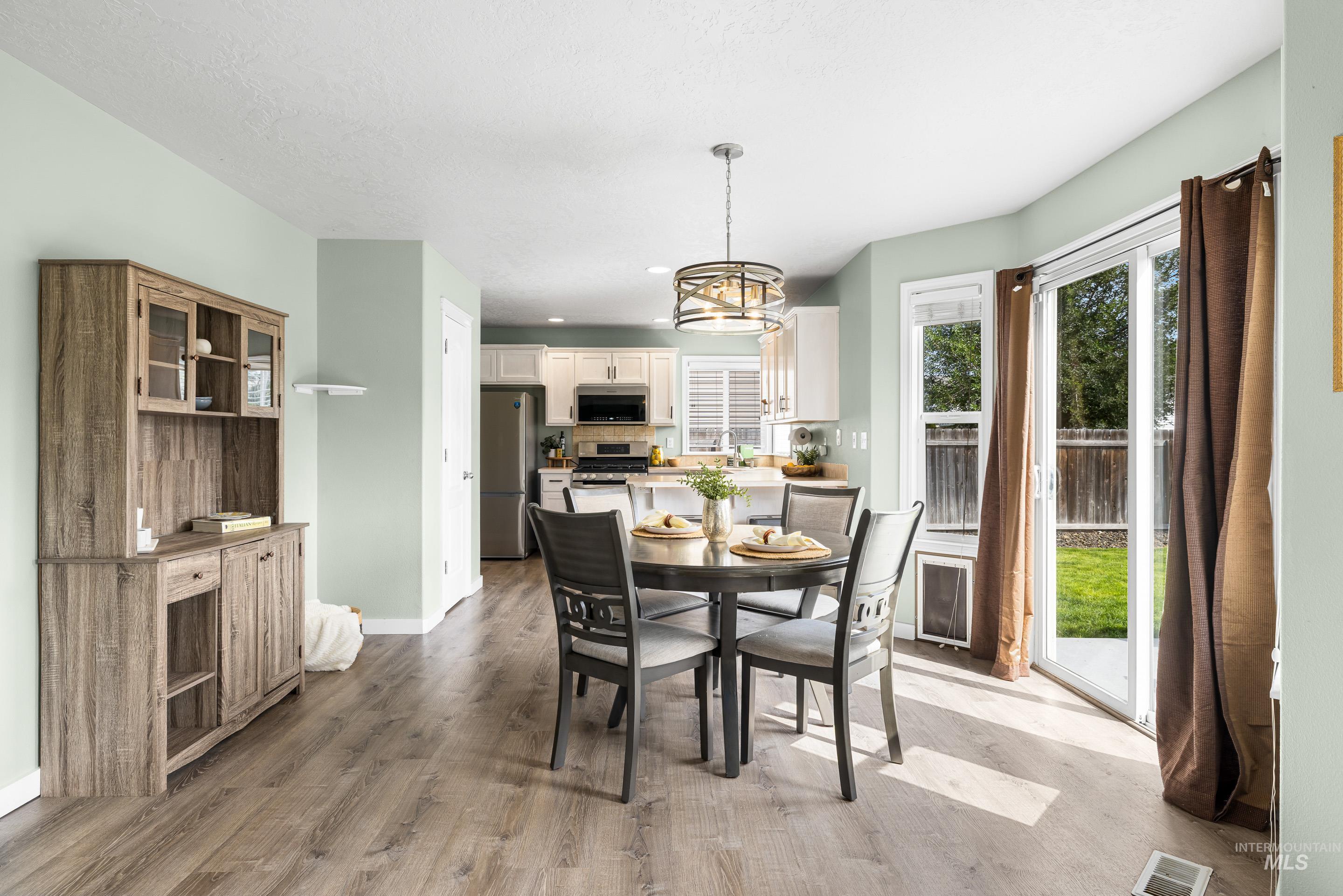 Dining room with light wood finished floors, recessed lighting, and a chandelier