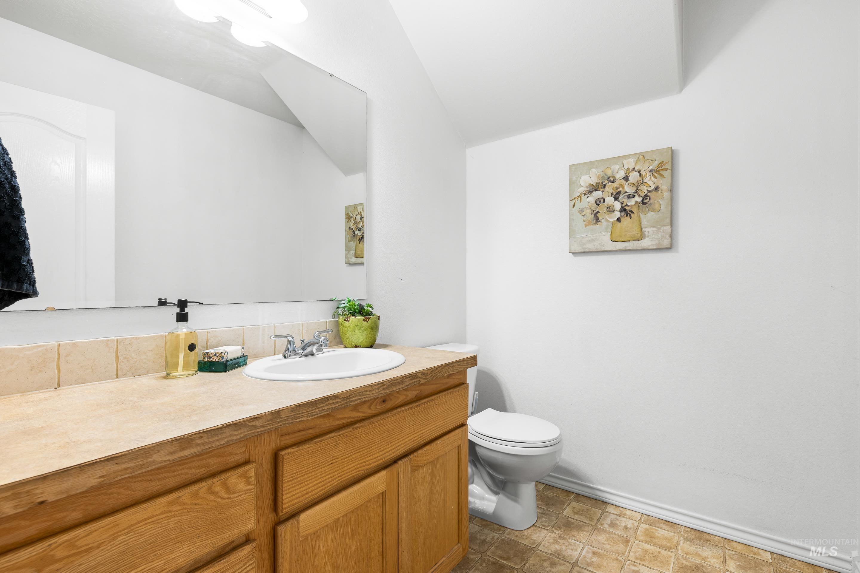 Half bathroom featuring vanity and toilet