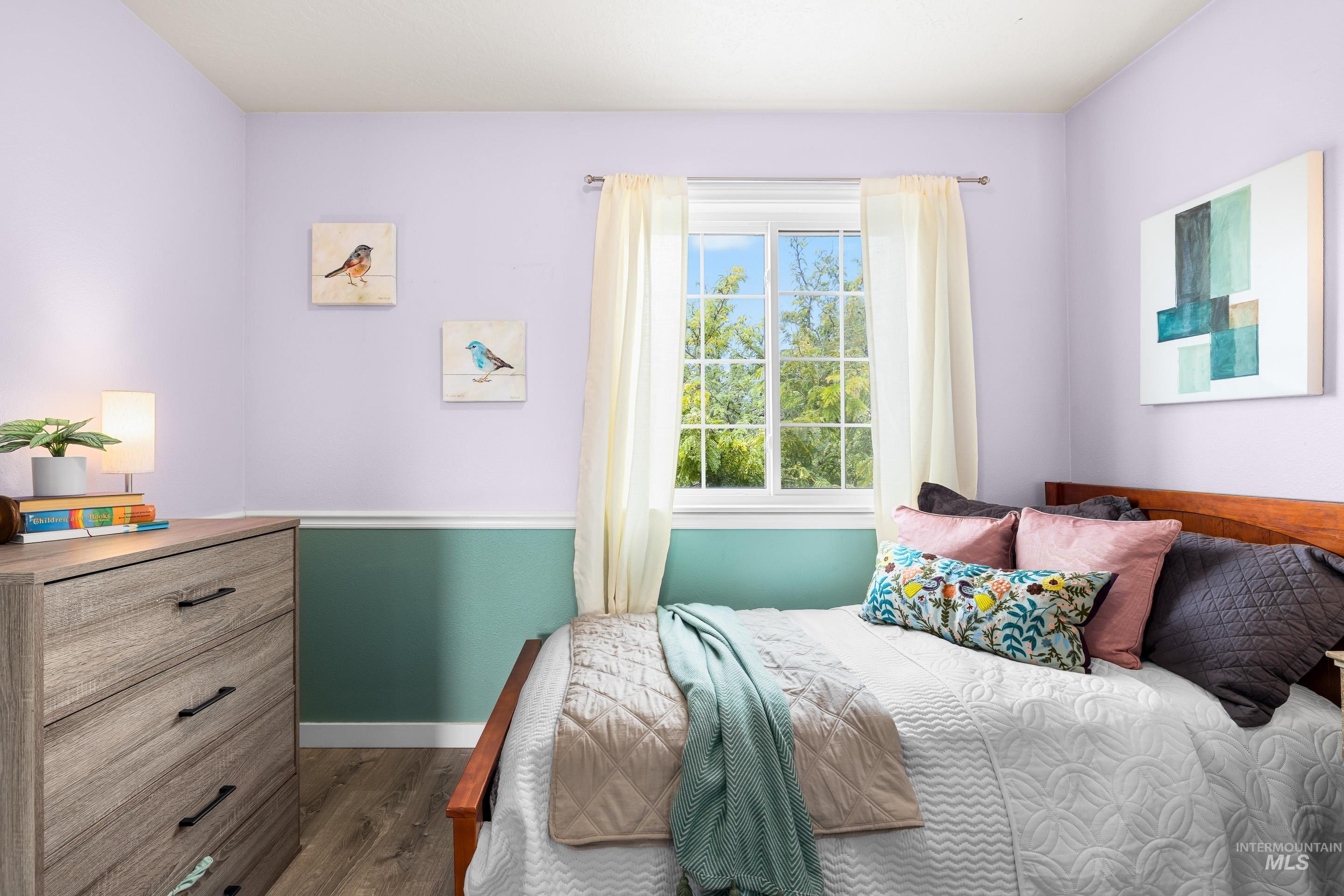 Bedroom with wood finished floors and baseboards