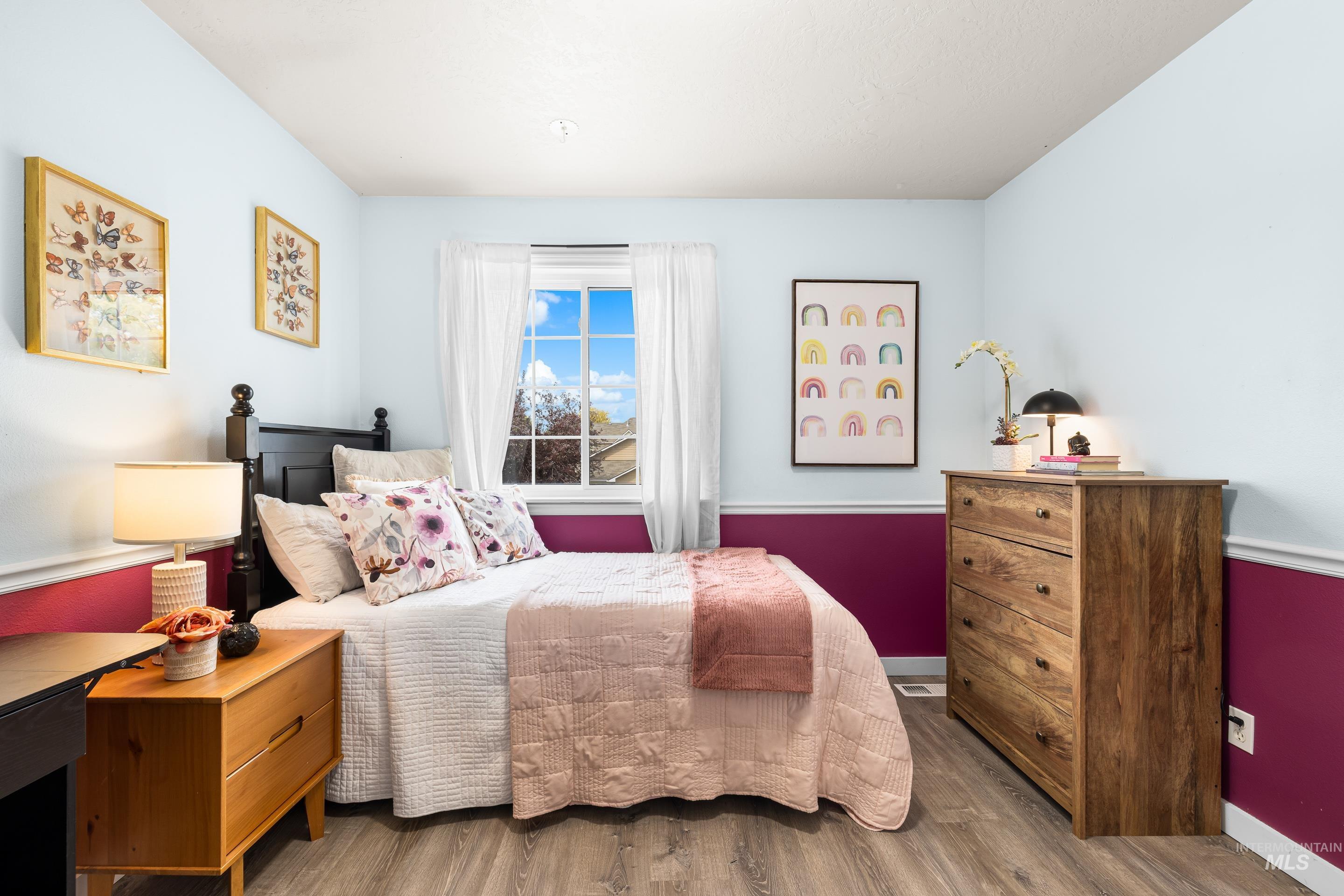Bedroom with wood finished floors and baseboards