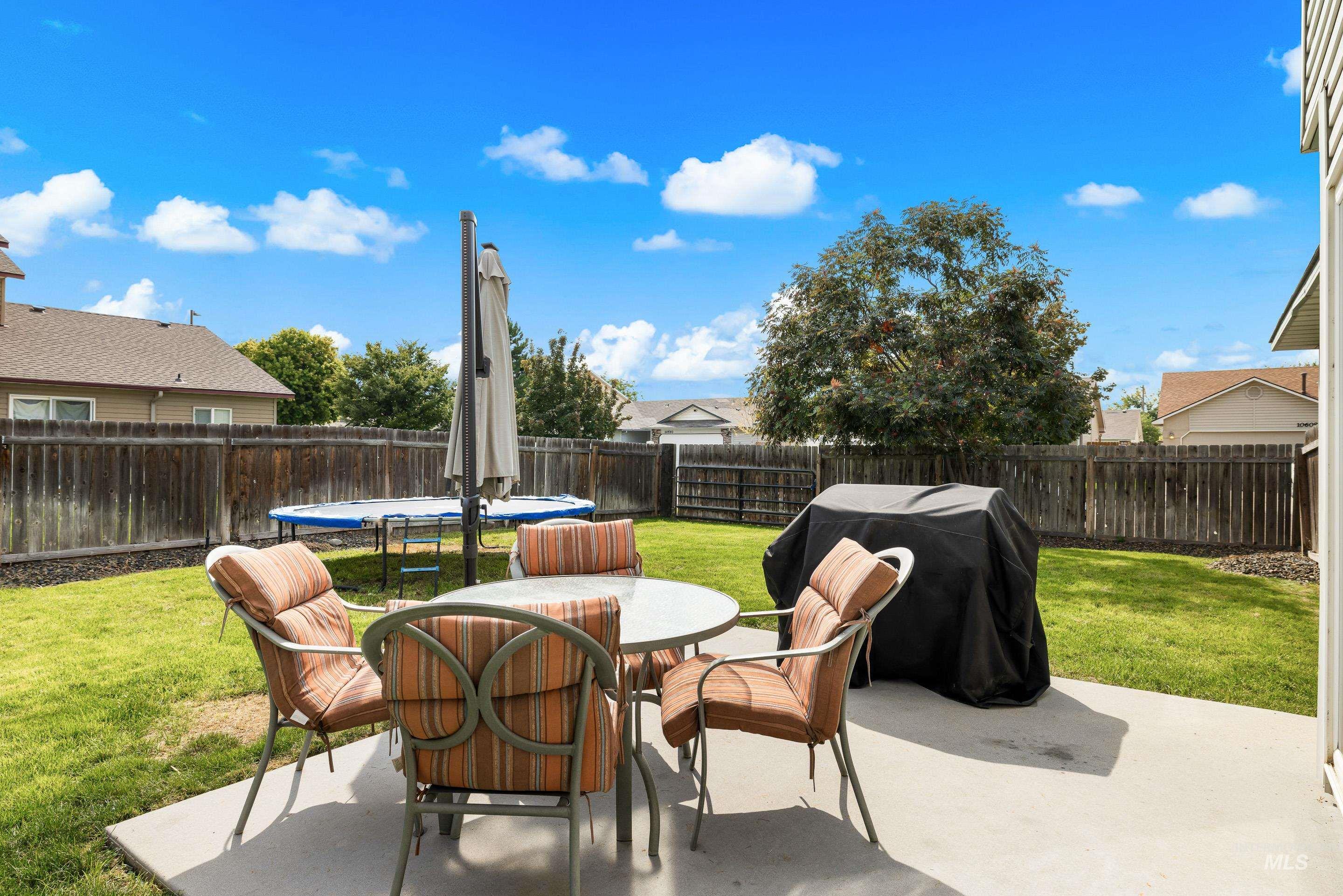 Fenced backyard with a patio, grilling area, and outdoor dining area